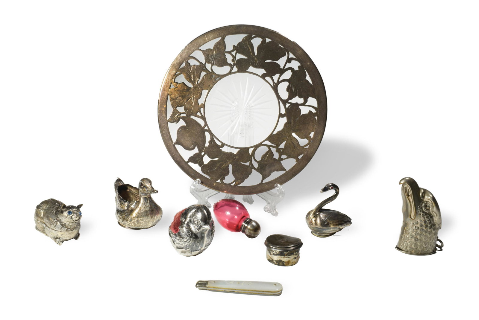 9 Silver Items, Including Figural: A group of 9 silver items. Includes: a sterling duck-form salt container; a swan-form salt shaker; a sterling silver chick-form pincushion; a sterling lidded snuff box; a glass trivet with sterling ov