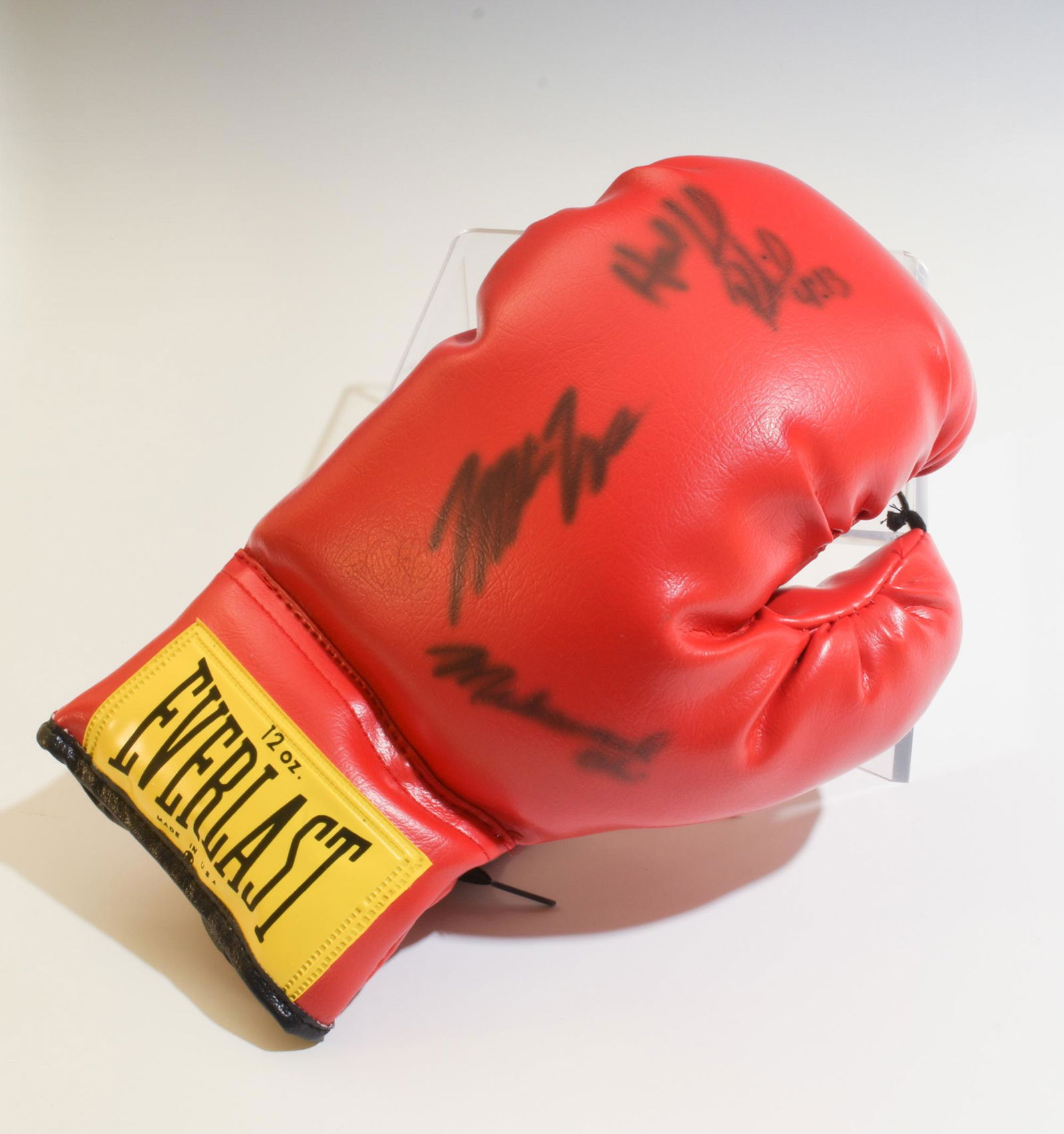 Muhammad Ali, Mike Tyson, Evander Holyfield Signed: An Everlast 12 ounce boxing glove signed by Muhammad Ali, Mike Tyson, and Evander Holyfield in display case. With Gallery of History label under case. Dimensions are: Glove, 12 inches, 30.5 cm long. D