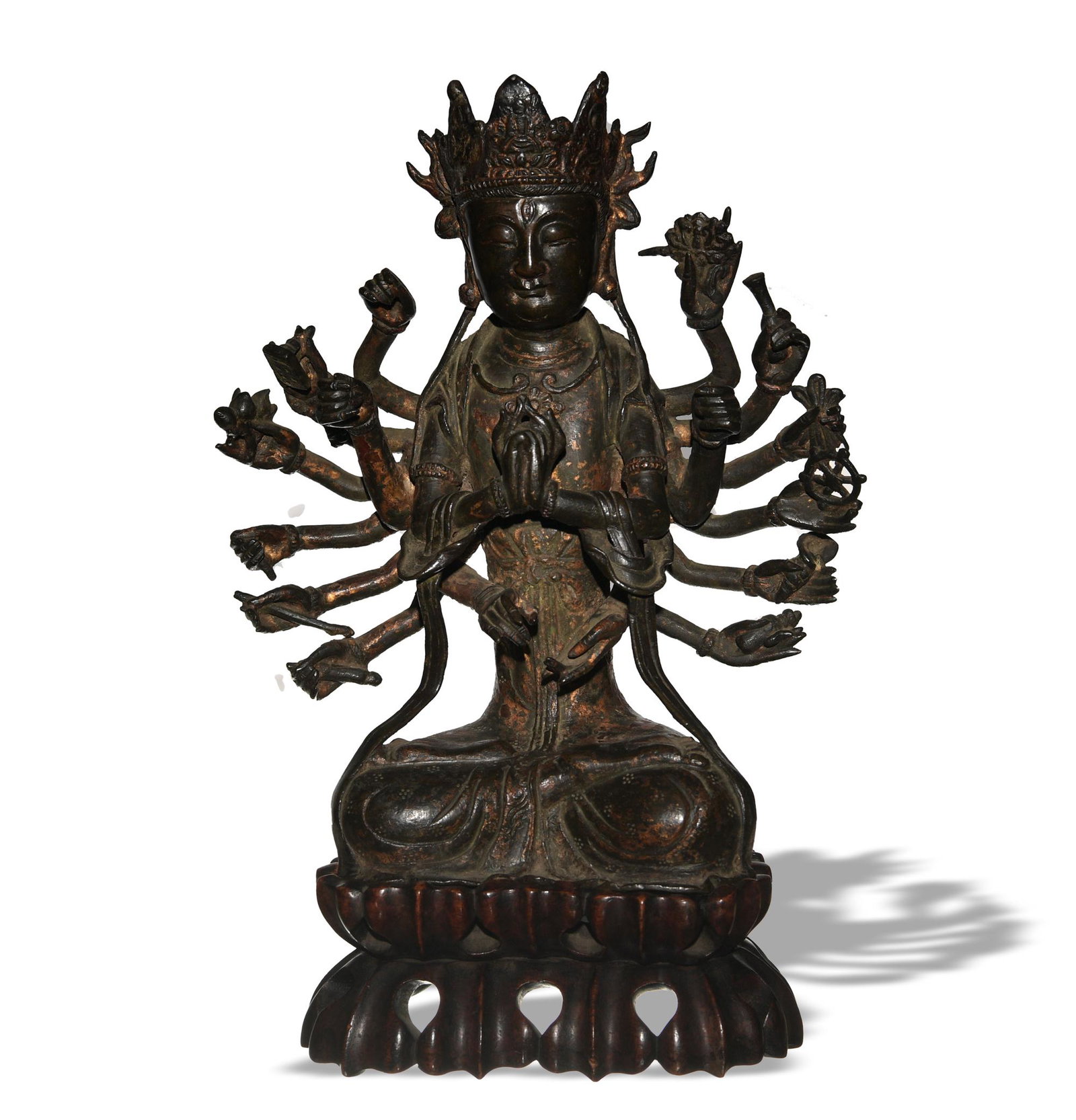 Chinese Bronze Seated Guanyin, Ming: A Chinese gilt bronze seated Guanyin dating from the Ming dynasty with a hardwood stand. Guanyin is seated in dhyanasana position with two sets of arms in two mudras. She holds auspicious items in her