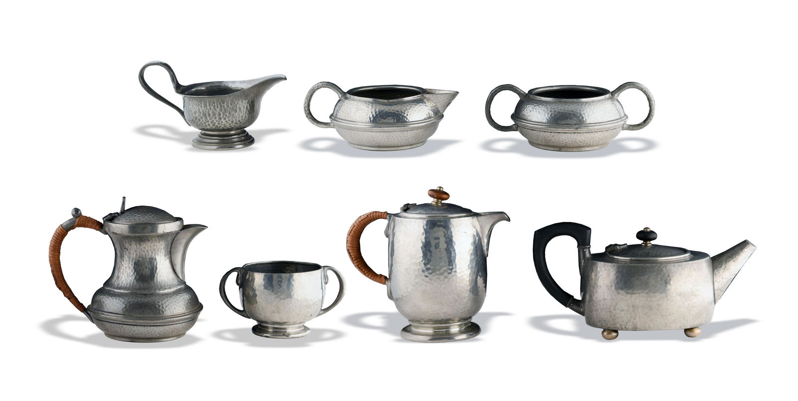 7 Archibald Knox Tudric and Other Pewter Pieces: Hammered Arts and Crafts pewter, 4 pieces of Tudric and 3 marked British-made pewter. Lot contains two creamers, two sugar bowls, and three teapots in hammered finish. Dimensions are: Largest teapot: