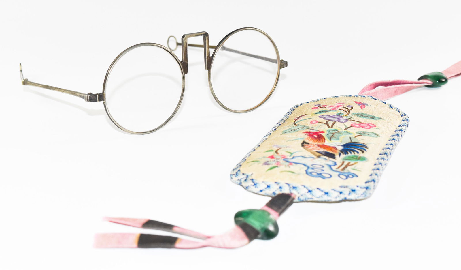 Chinese Glasses with Embroidery Sleeve, Late Qing: Silver framed eyeglasses with hinged temples, round temple tips, and round lenses. Case is embroidered with a rooster on one side and a kingfisher flying over a swimming duck on the other. Case closur