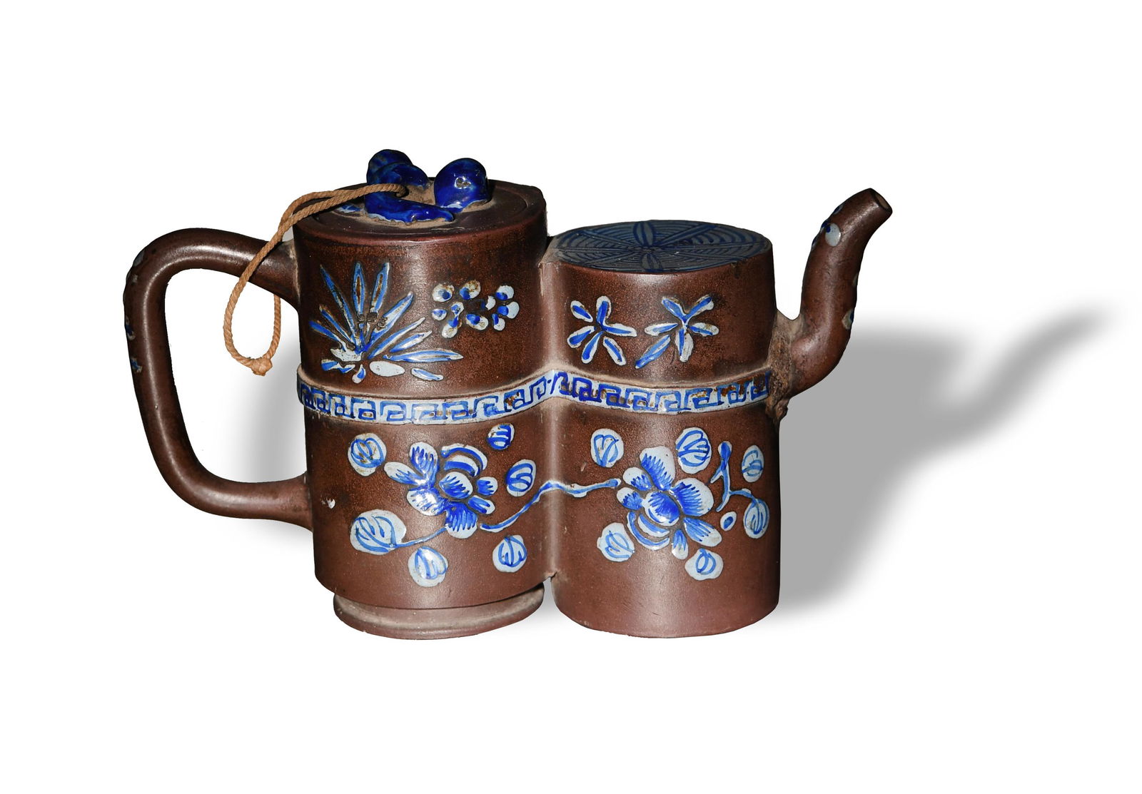 Chinese Zisha Teapot, 19th Century: A Chinese Zisha teapot dating from the 19th century and shaped like a pair of cylinders. The teapot is glazed with blue floral motifs and features a signature by the spout. Dimensions are: 4 1/2 inche