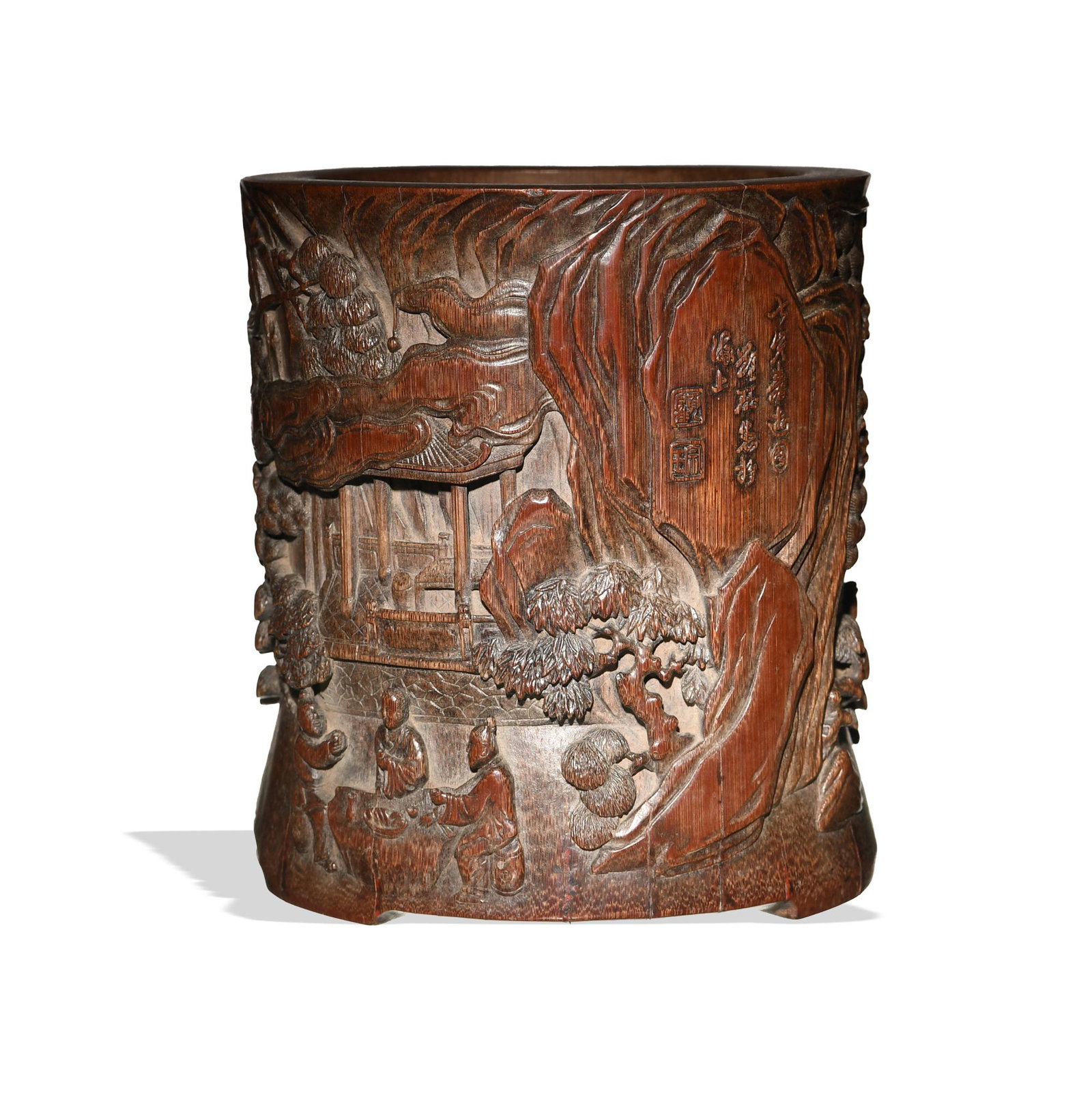 Chinese Bamboo Brush Pot Carved with Poem, 18th Century: A Chinese carved bamboo brush pot dating from the 18th century. The exterior features seven figures in a landscape with pine trees. There is a poem carved on one side with two seals. Dimensions are: 6