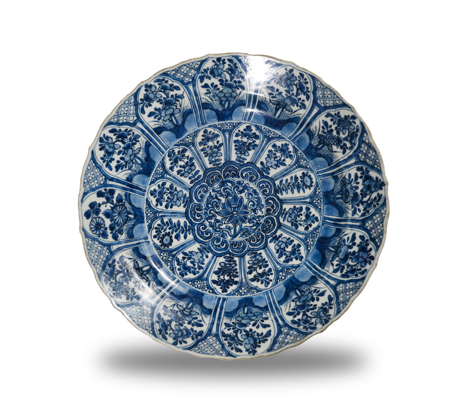 Chinese Blue and White Export Charger, 17-18th Century: A Chinese blue and white export charger dating from the 17th or 18th century. The interior of the lobed plate features a Kraak ware design with flowers surrounding a central lotus motif. The exterior 