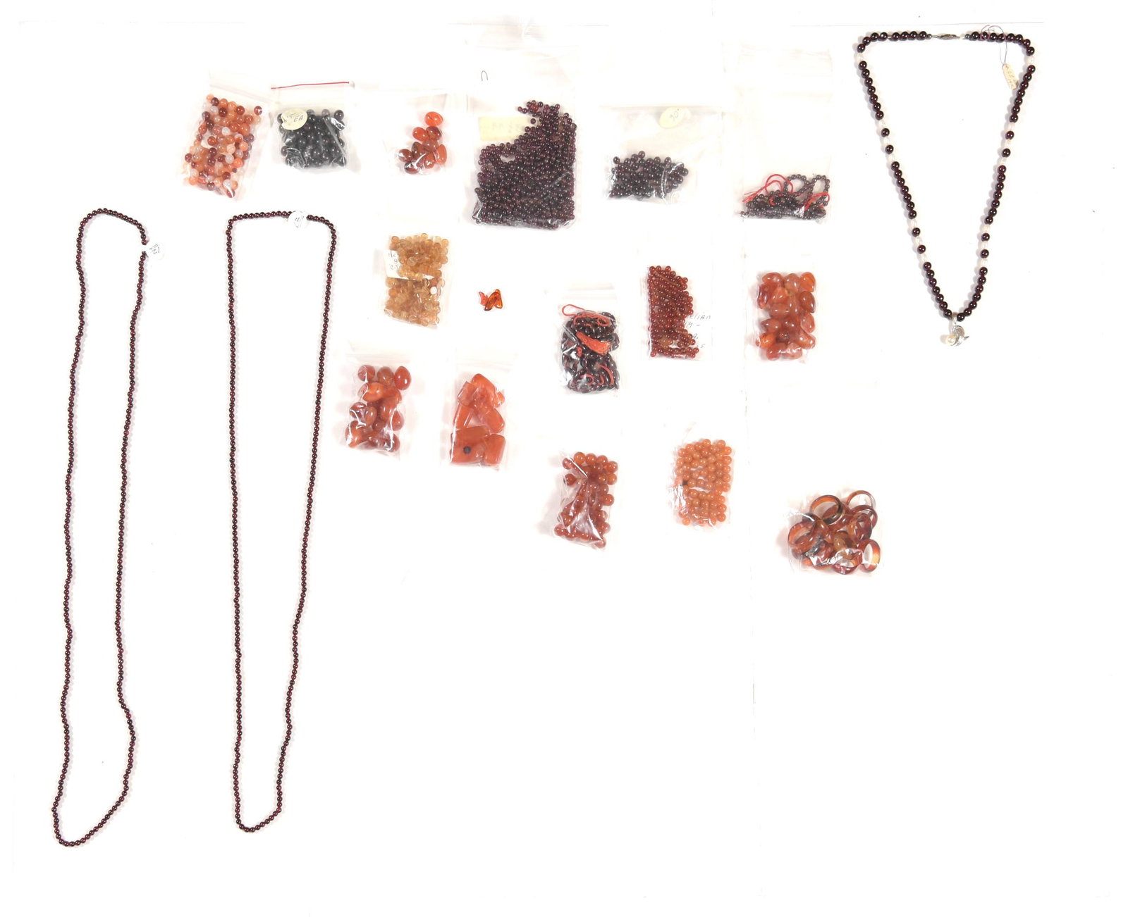 Loose Carnelian and Garnet Beads, Garnet and 14K: A garnet bead necklace with freshwater pearls and a 14K white gold pendant. Three bags of garnet beads, bag of hessonite garnets, nine bags of carnelian beads and rings. Weight: Garnets: 308.7 grams. 
