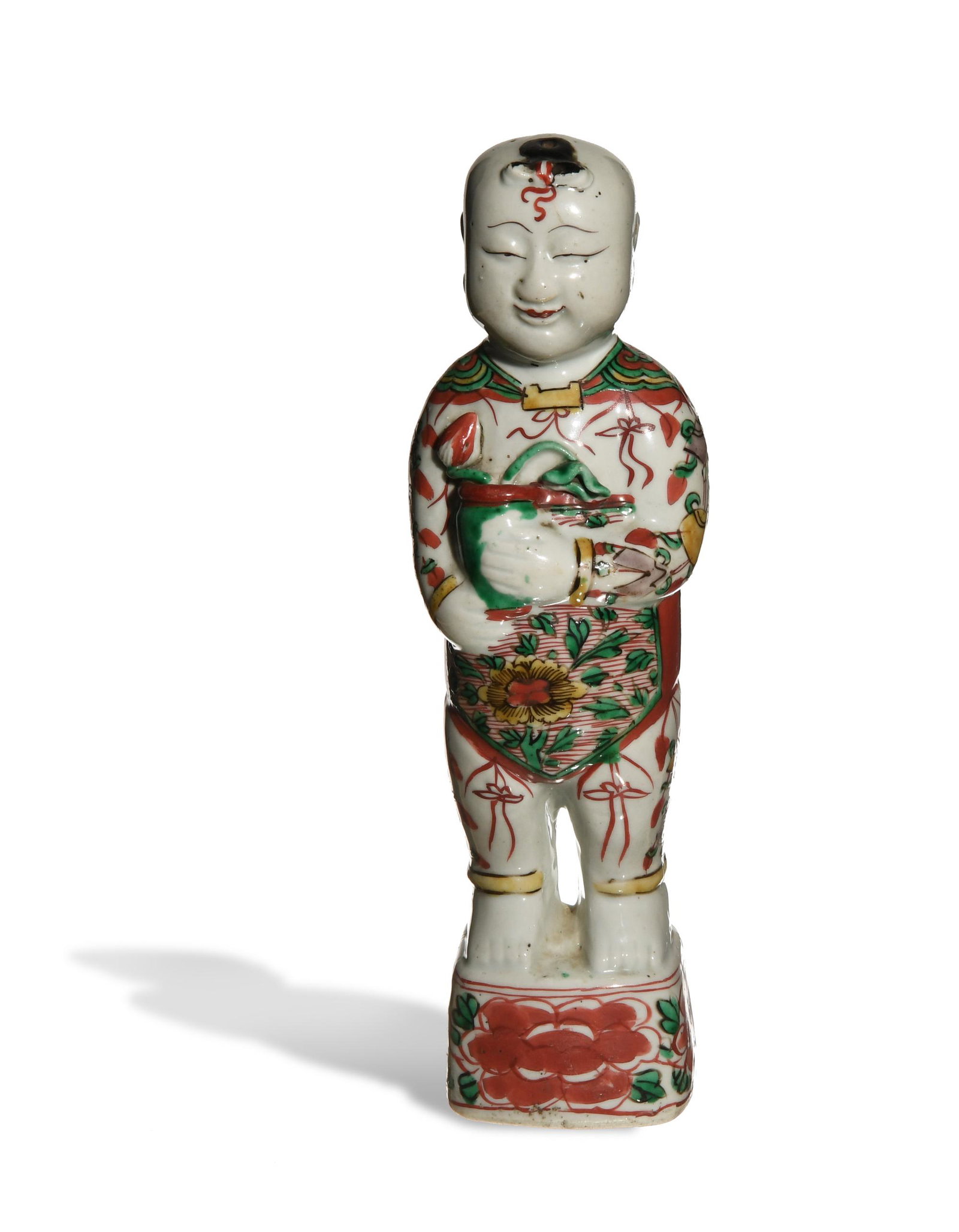Chinese Famille Verte Statue of a Boy, 17th Century: A porcelain figurine of a boy dating from the 17th century. The boy is depicted holding a vase with a lotus bud and leaf. His outfit features ruyi and other auspicious symbols. He is standing on a squ
