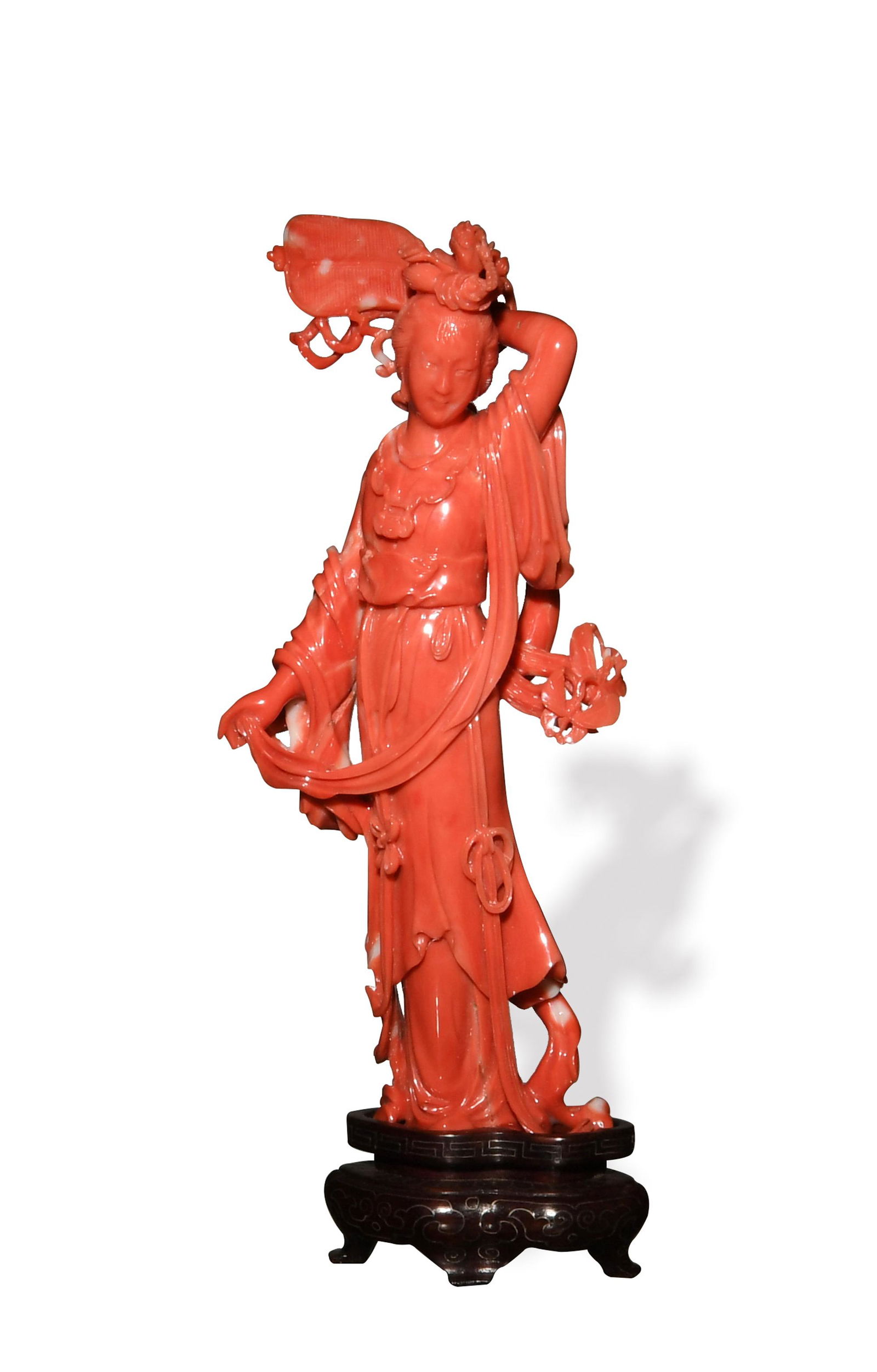 Chinese Coral Statue of a Court Lady: A Chinese coral statue of a court lady with a hardwood stand. The lady stands with a fan in one hand behind her head and the other hand holding her robes which features two butterflies. Dimensions are