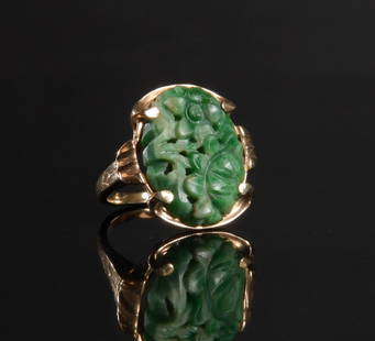 14K Gold and Carved Jadeite Ring: 14K yellow gold ring with carved and pierced floral jadeite. Dimensions are: Weight 5.7 crams (.18 ozt.). Ring size 7. All measurements are approximate. Condition: Crack to jadeite. Provenance: