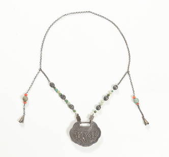 Chinese Silver Lock Necklace with Jadeite and Coral: A Chinese silver lock necklace dating to the 19th century. The necklace has jadeite, coral, and silver beads. There are two chains that hang from the middle of the necklace with silver charms made to