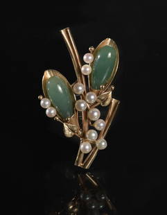 14K Gold Carved Jadeite and Pearl Brooch: A 14K gold carved jadeite and pearl brooch made by Mingâ€™s jewelry Hong Kong. The jadeite features foliate carving with a 14K gold pin with a scroll border and floral designs. Total Weight: