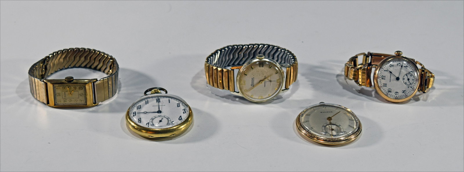 Gold Filled Pocket and Wristwatches: This Lot includes a Hamilton 14K gold filled pocket watch, a Bulova gold filled pocket watch, a Waltham 10K gold filled wristwatch and a gold filled band, a Elgin 10K gold filled tank watch, and a Ber