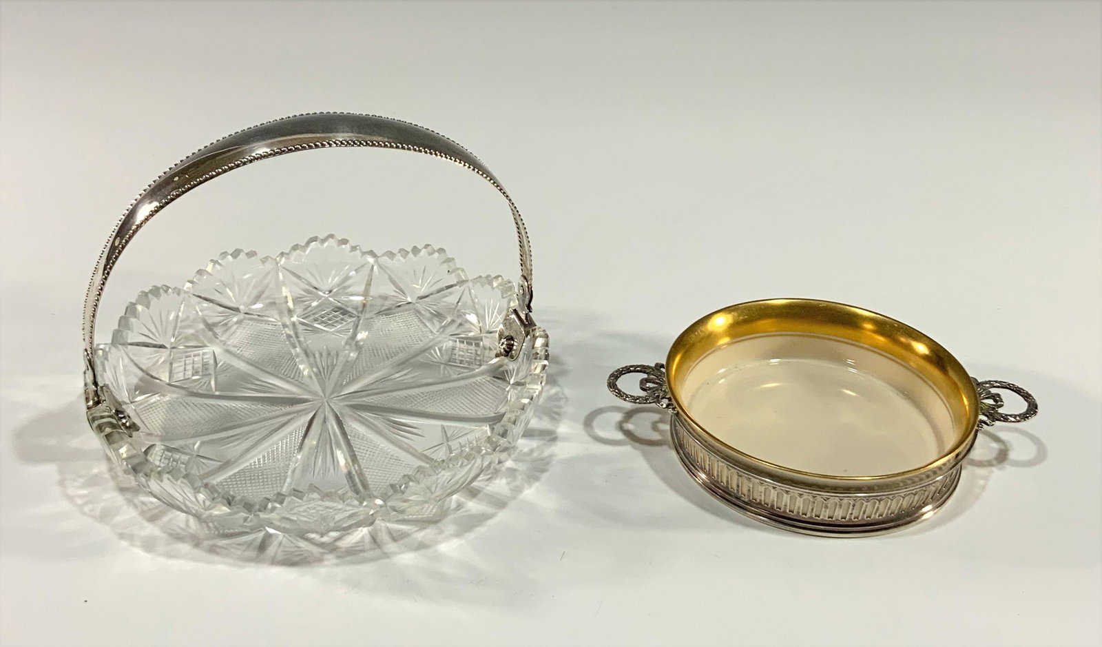 Sterling and Cut Glass Basket, Sterling Wine Coaster: A group of glassware including a cut glass basket with a sterling handle with a Netherlands, Amsterdam city mark, and date mark 1926, and a sterling R. Wallace wine coaster with a Lenox gilt porcelain