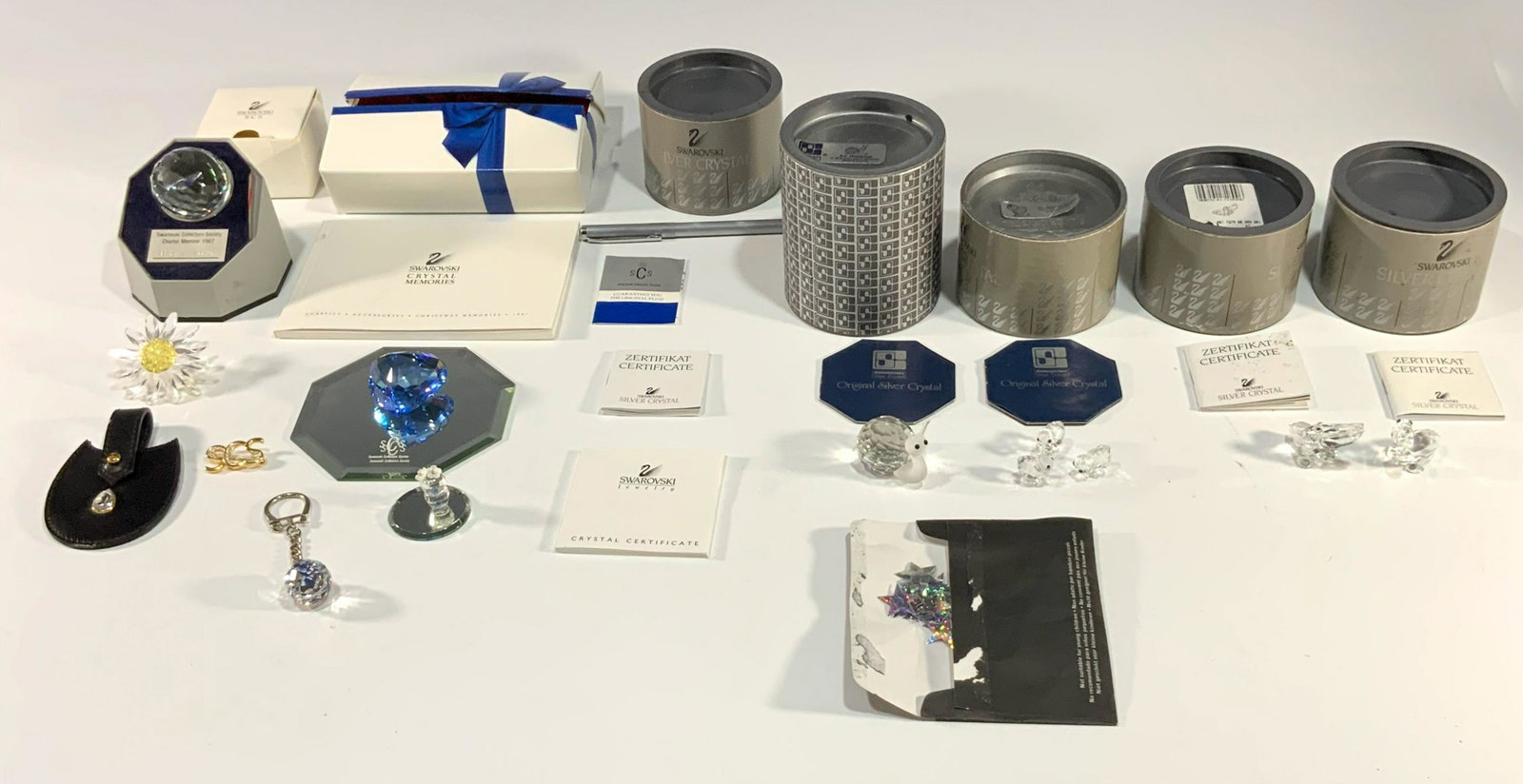 Swarovski Crystal Lot inc. SCS Items: A group of Swarovski crystal items including a crystal snail, 3 crystal chicks, 2 crystal pelicans, a presentation mirrors, a blue crystal heart, a purse toggle with a crystal, a crystal daisy, a tiny
