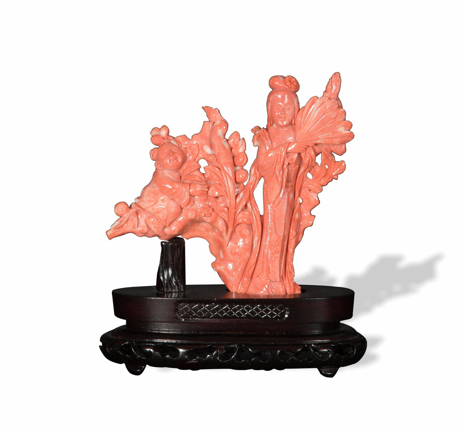 Chinese Coral Carving of a Lady and a Boy: A Chinese coral carving of a woman and a child that comes with a wooden stand. The woman stands and holds a fan. Beside her is a flowering tree, which supports the child as well as a bird. Dimensions 