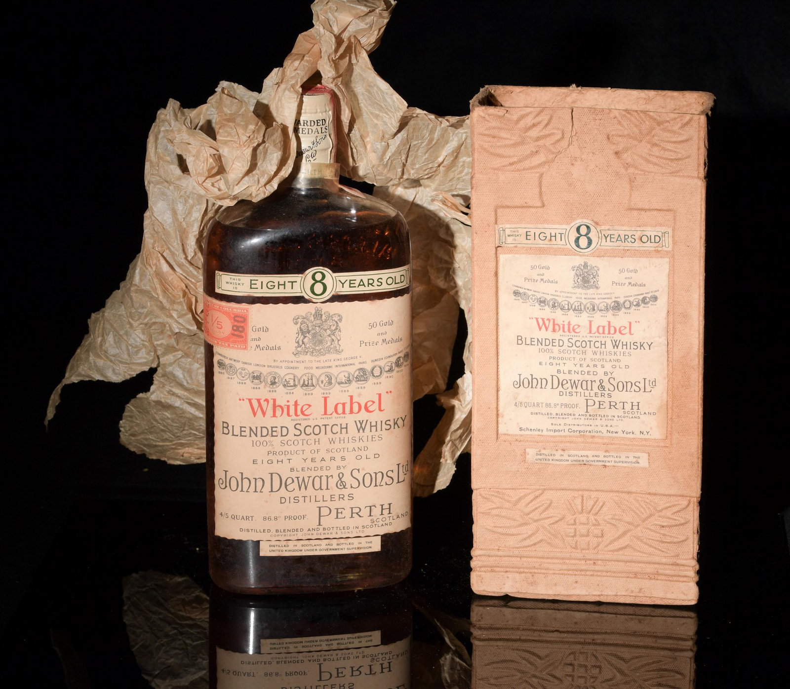 Boxed & Sealed 1939 Dewar's 8 Year White Label: A boxed and sealed bottle of Dewar's, 8 year old, White Label blended Scotch Whisky. The bottle retains some of the paper wrapping and the Federal and Washington DC tax labels. On the verso the label 