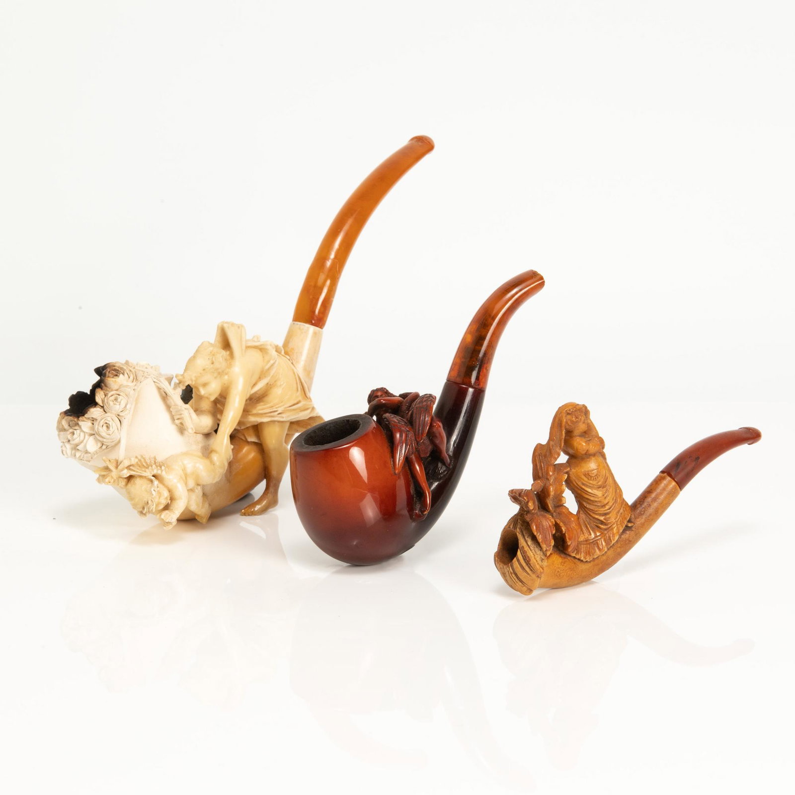 Lot has an amber colored pipe depicting Leda and the swan and two cased meerschaum pipes, one of: Lot has an amber colored pipe depicting Leda and the swan and two cased meerschaum pipes, one of Venus and Cupid and the other of a partially nude Victorian woman. Dimensions are Largest, L: 8 3/4 inc
