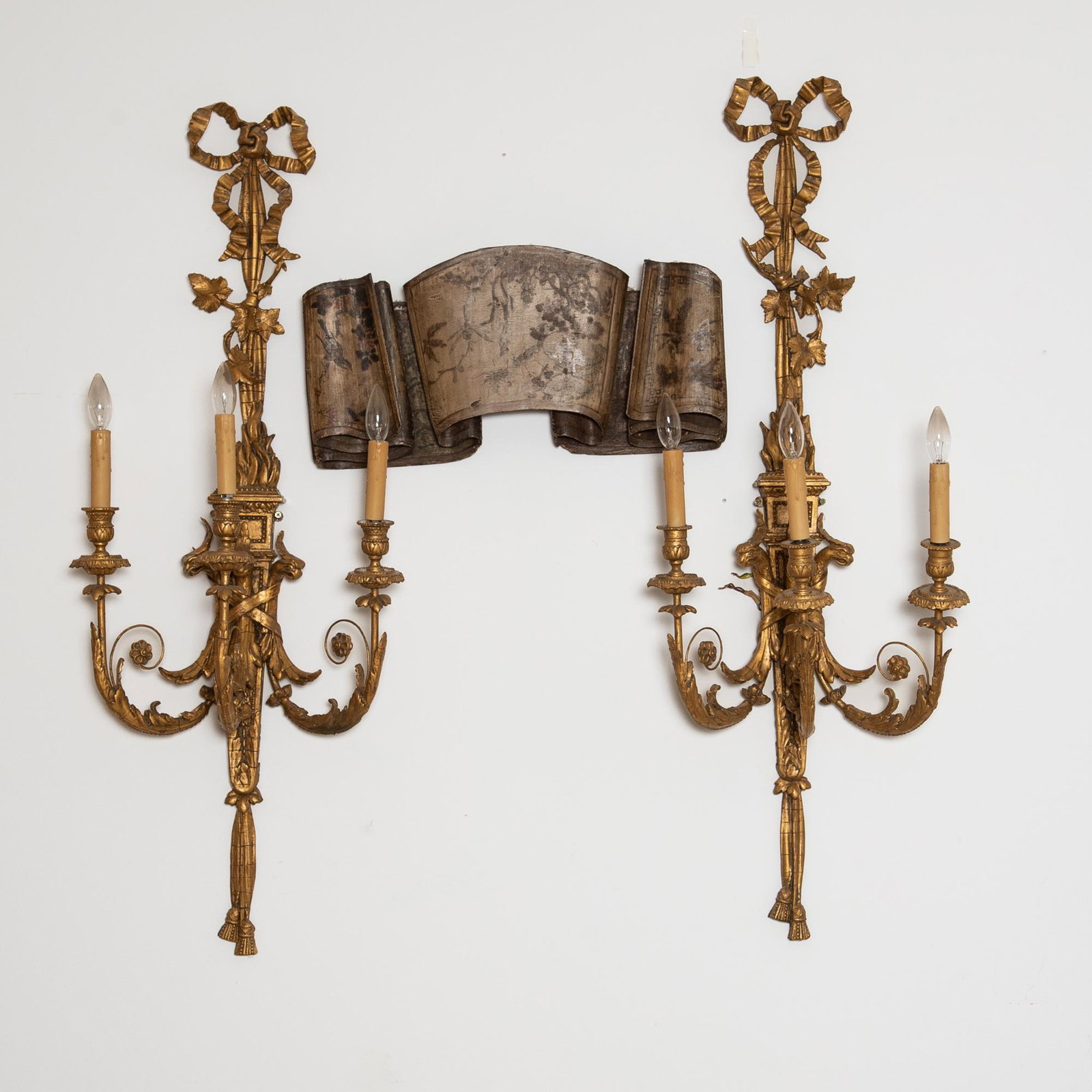 A pair of large George III style giltwood and gesso three-light wall sconces, late 19th/early 20th: A pair of large George III style giltwood and gesso three-light wall sconces, late 19th/early 20th century, decorated floral and phoenix motifs. Sold together with a painted wood Southeast Asian style