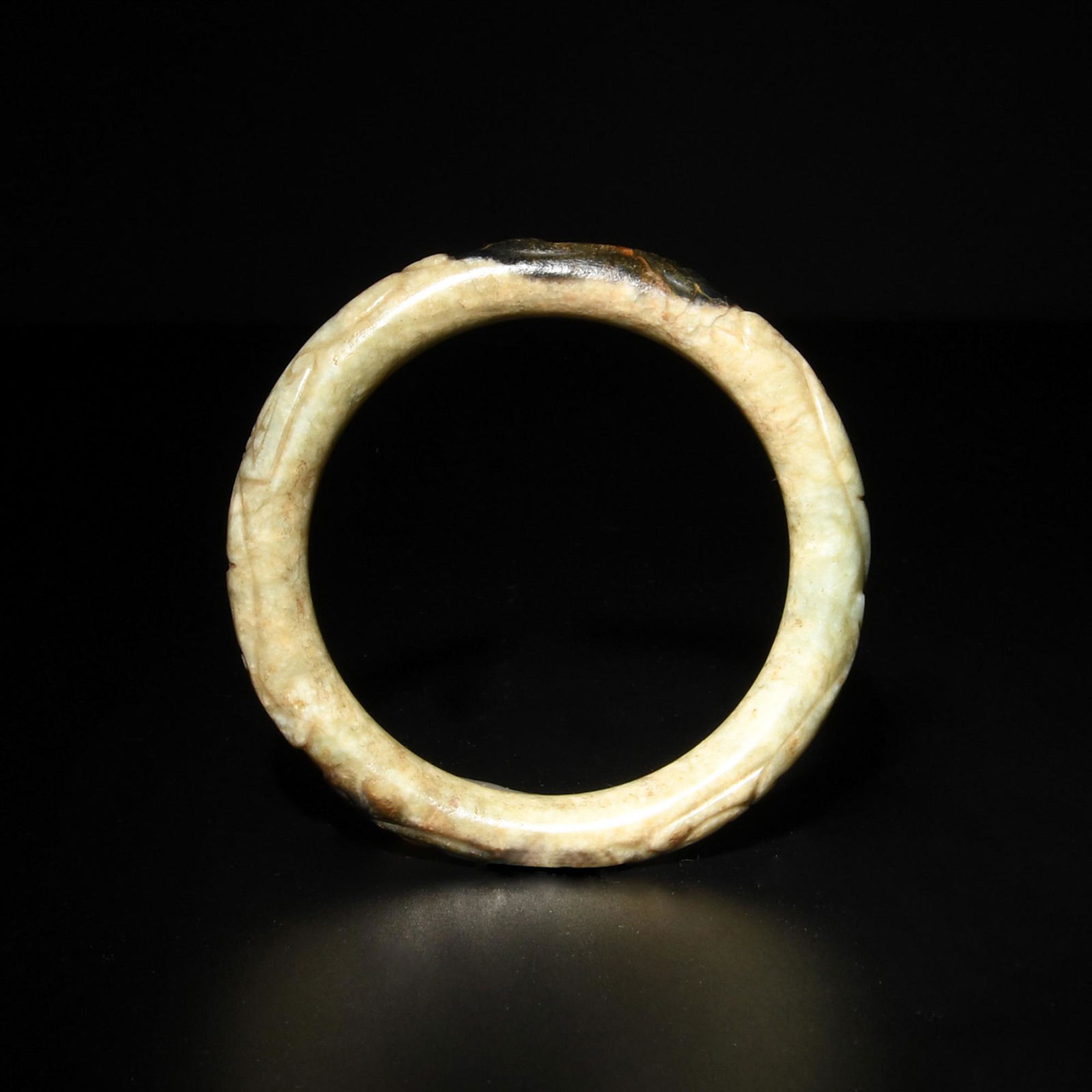 A Chinese jade bangle dating from the Ming dynasty. The bangle is carved with a pair of dragons. (1 of 3)