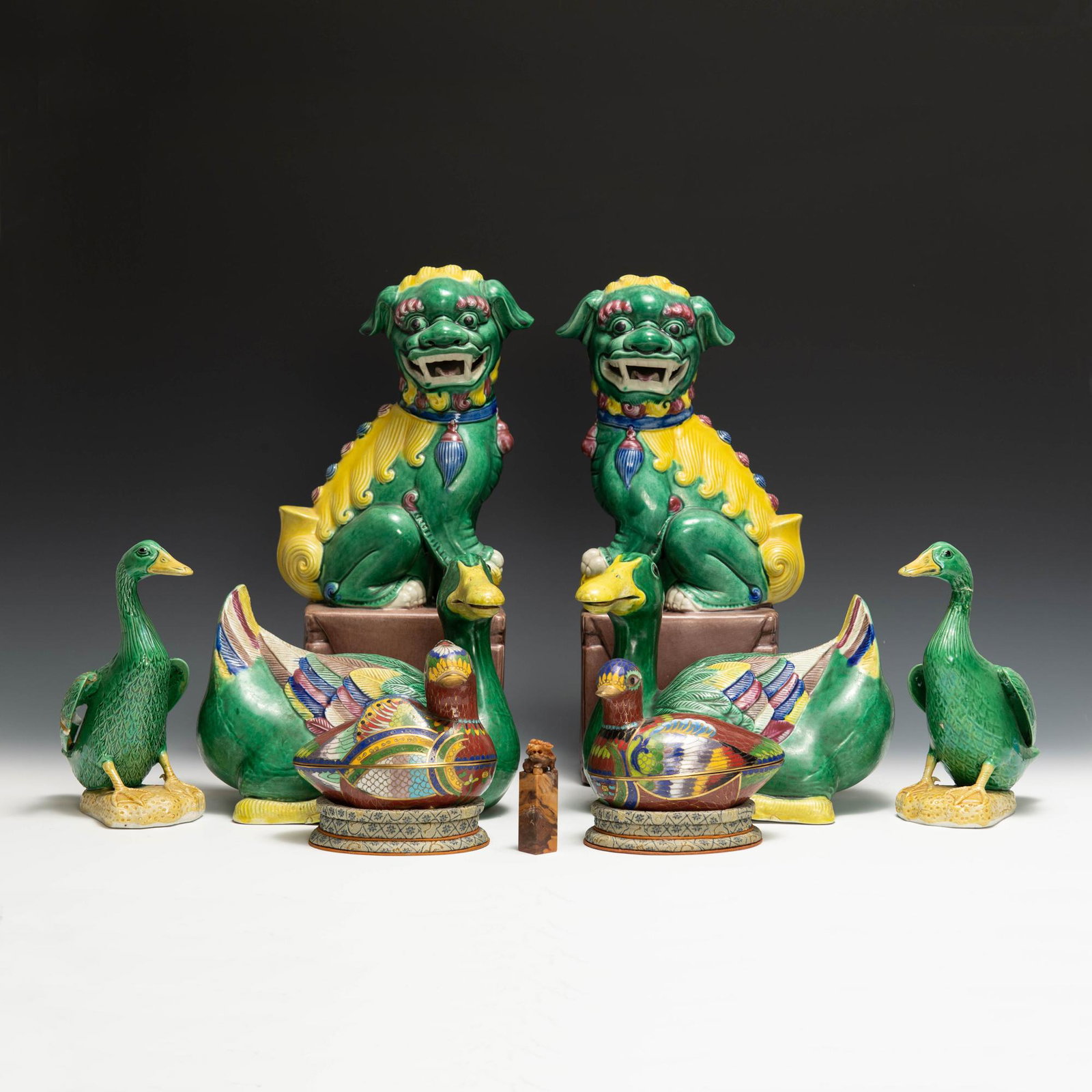 Lot includes a small soapstone seal with foo dog, two ceramic foo dogs, four ceramic ducks and two: Lot includes a small soapstone seal with foo dog, two ceramic foo dogs, four ceramic ducks and two cloisonne ducks. Dimensions are: sizes vary, the largest measures 12 1/4 inches tall X 5 1/2 inches w