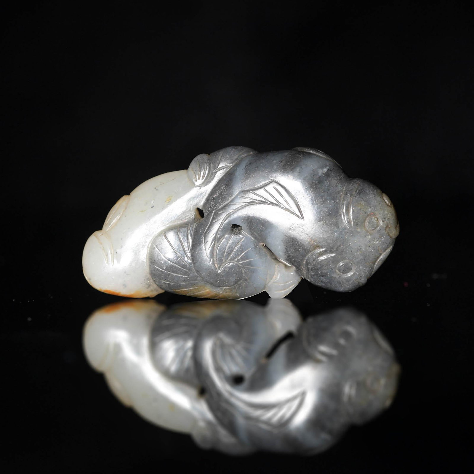 A Chinese black and white jade carving of a pair of catfish, 18th/9th century: A Chinese black and white jade carving of a pair of catfish 18th/9th century H: 1 1/4, W: 2 1/2 in. H: 3.2, W: 6.4 cm. All measurments are approximate. Provenance: Mr. Kao, New Mexico. Condition: It i