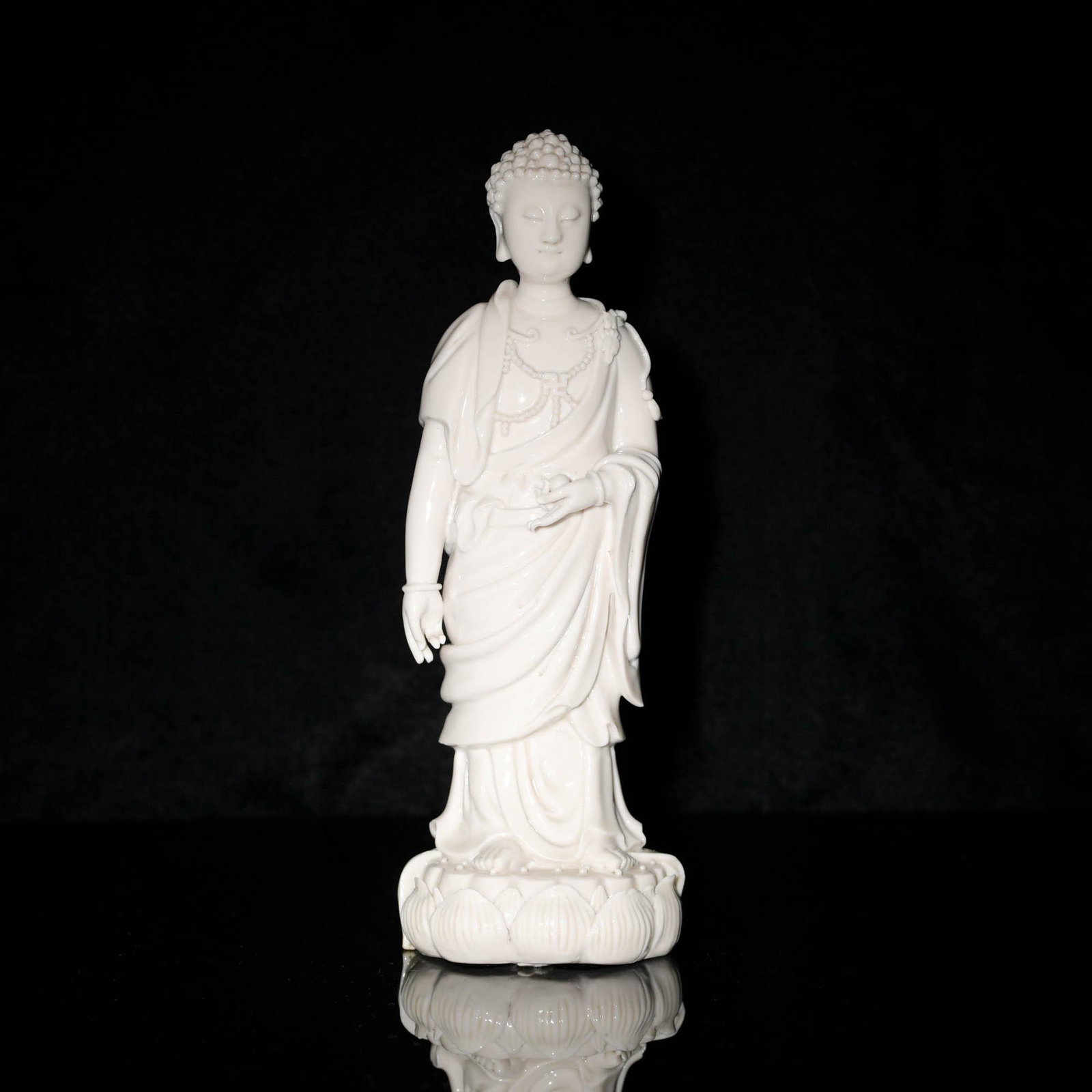 A Chinese blanc de chine statue of a standing Buddha, 18th/19th century: A Chinese blanc de chine statue of a standing Buddha 18th/19th century With two marks to verso. H: 9, Dia: 2 3/4 in. H: 22.86, Dia: 6.99 cm. All measurments are approximate. Provenance: Mr. Burns, Sou