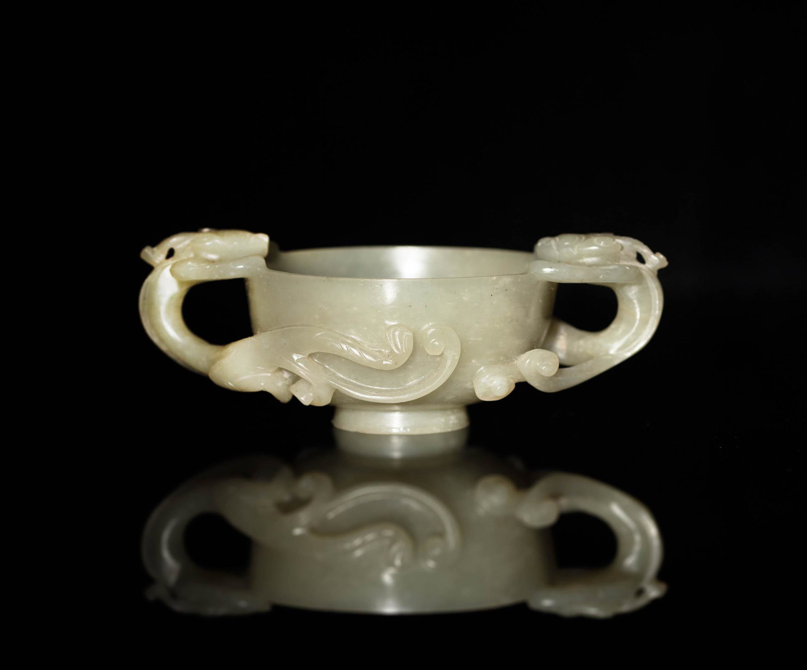 A Chinese white jade chilong double-handle cup, Ming dynasty: A Chinese white jade chilong double-handle cup Ming dynasty H: 1 5/8, W: 4 7/8, D: 2 7/8 in. (H: 4.13, W: 12.38, D: 7.30 cm.) Provenance: Mrs. Hsu, Pennsylvania. Acquired in Hong Kong in the 1980s and