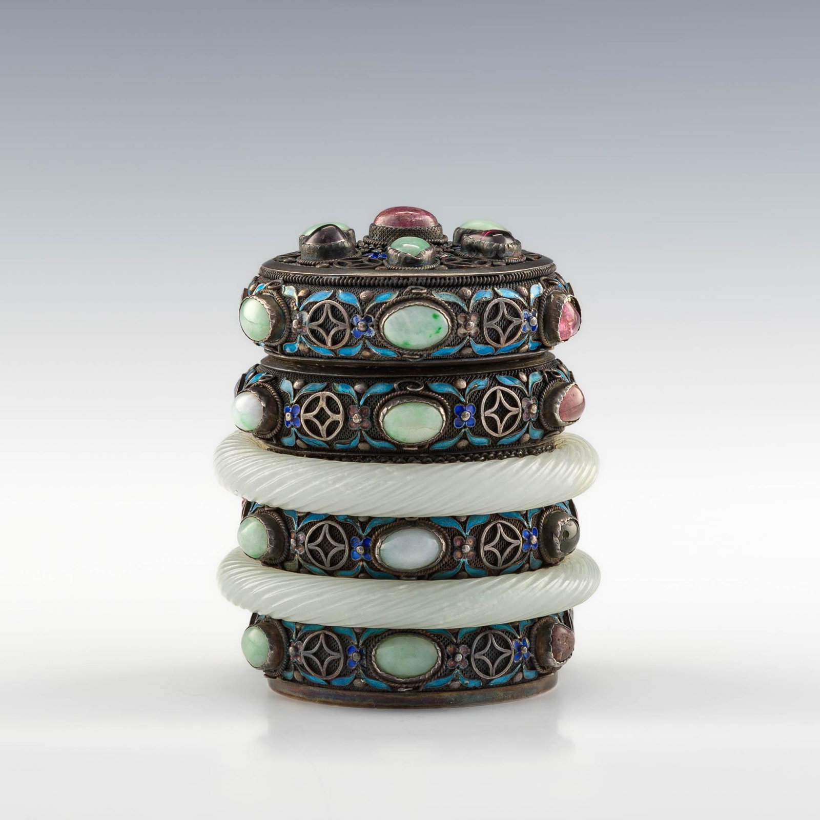 A Chinese silver enameled lidded jar with carved jade, 18th century or earlier: A Chinese silver enameled lidded jar with carved jade 18th century or earlier With "SILVER" embossed to the underside. H: 3 3/4, Dia: 3 1/8 in. (H: 9.53, Dia: 7.94 cm.) Weight: 419 g. Provenance: Mr. 