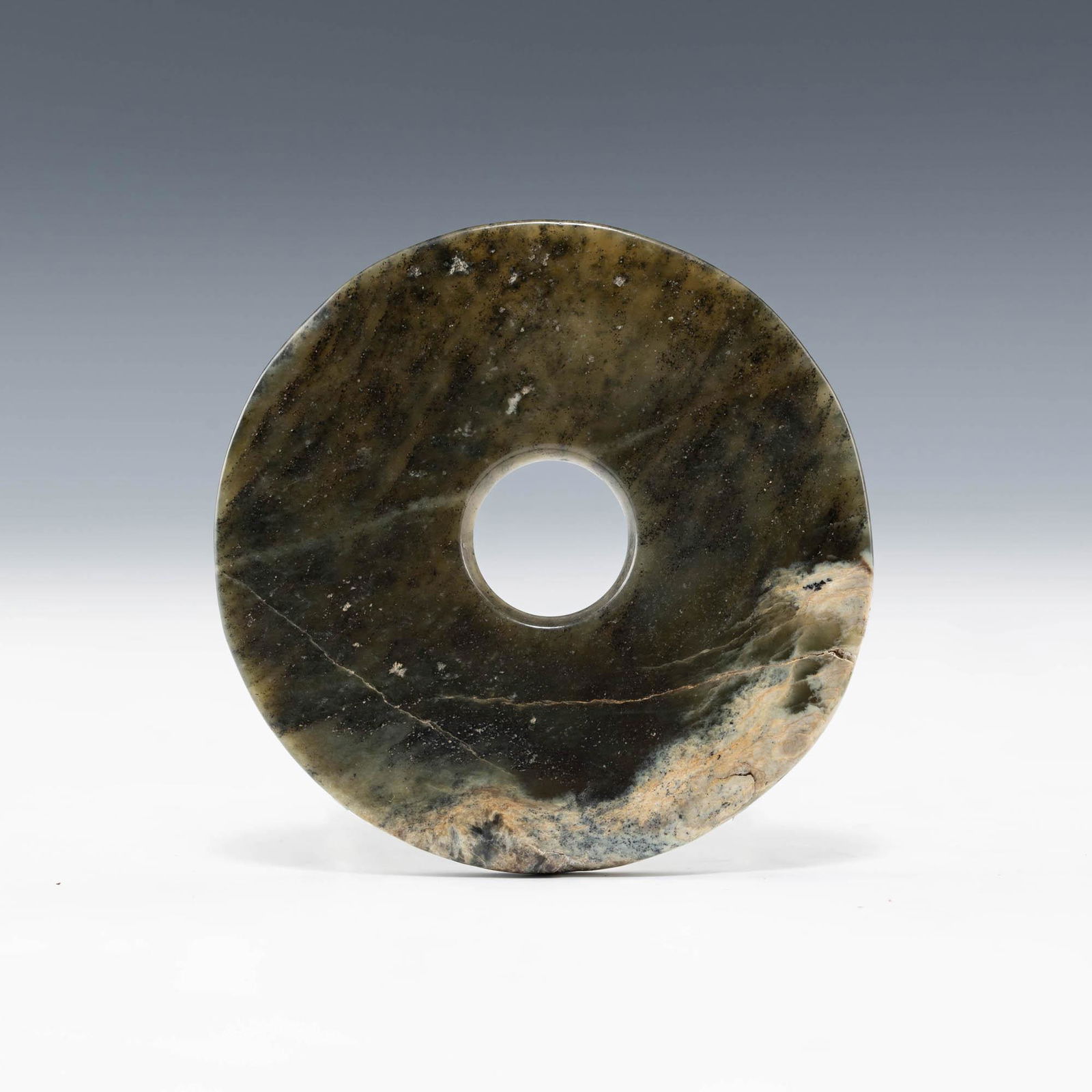 A Chinese celadon jade bi, Spring and Autumn period: A Chinese celadon jade bi Spring and Autumn period Dia: 3 7/8, D: 1/8 in. Dia: 9.84, D: 0.32 cm. Provenance: Mr. Lee, Houston, Texas. Items were collected by his father over 30 years ago.