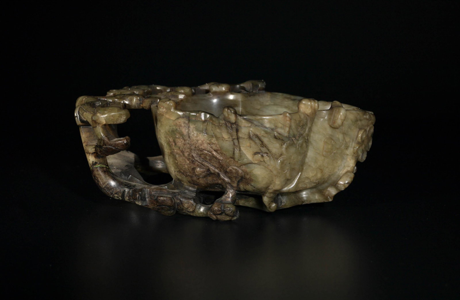 A Chinese carved chicken bone jade cup, Ming dynasty: A Chinese carved chicken bone jade cup Ming dynasty Interior of cup carved with lobed flower design; exterior with carved flowering branches. H: 2 1/2, W: 6 3/4, D: 5 in. H: 6.35, W: 17.15, D: 12.7 cm