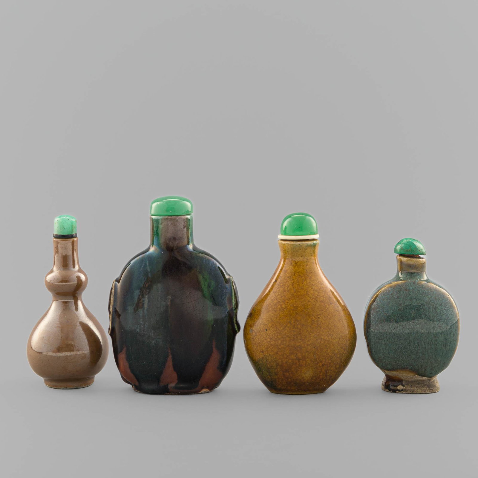 Four Chinese monochrome-glaze snuff bottles, 19th century: Four Chinese monochrome-glaze snuff bottles 19th century Comprising one bottle of black, red, and green color and beast-mask handles to either side with obscured character mark to underside; one bottl