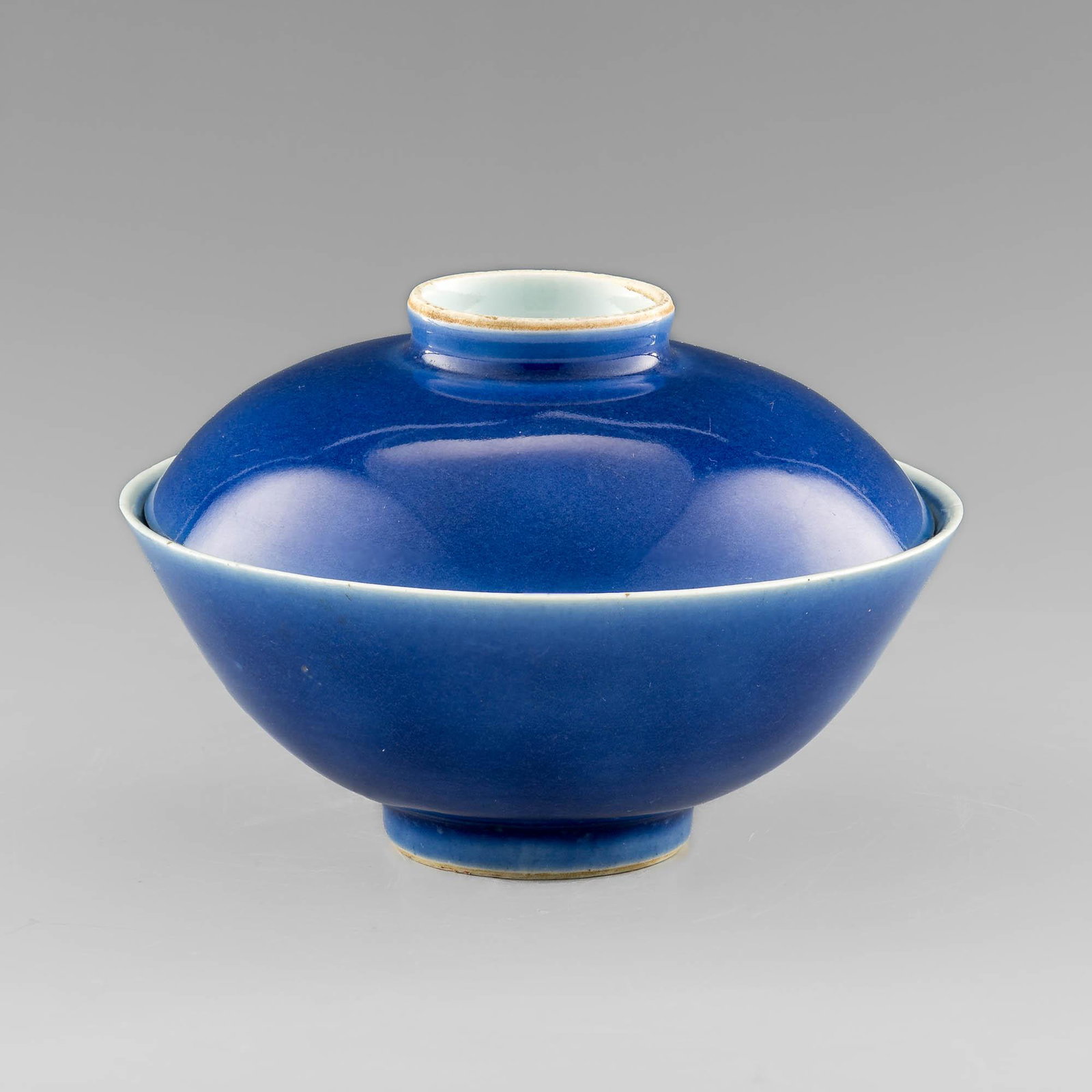 A Chinese blue-glaze lidded bowl with blue and white interior, Jiaqing period, Qing dynasty: A Chinese blue-glaze lidded bowl with blue and white interior Jiaqing period, Qing dynasty Featuring lotus scroll motif to interior; with six-character Jiaqing mark to lid and bowl underside H: 3 7/8,