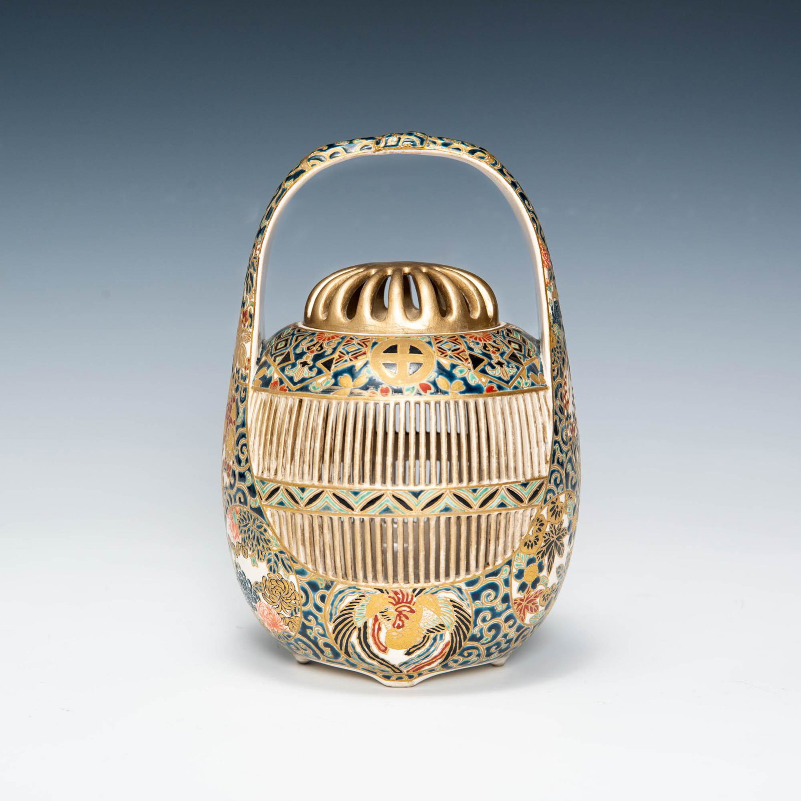 A Japanese satsuma reticulated basket, signed Eigyoko, late Meiji era: A Japanese satsuma reticulated basket signed Eigyoko, late Meiji era With gosu-blue-ground and two shimazu crests. Signature, inscription, and seal to underside. H: 8 1/2, Dia: 5 in. H: 21.19, Dia: 12