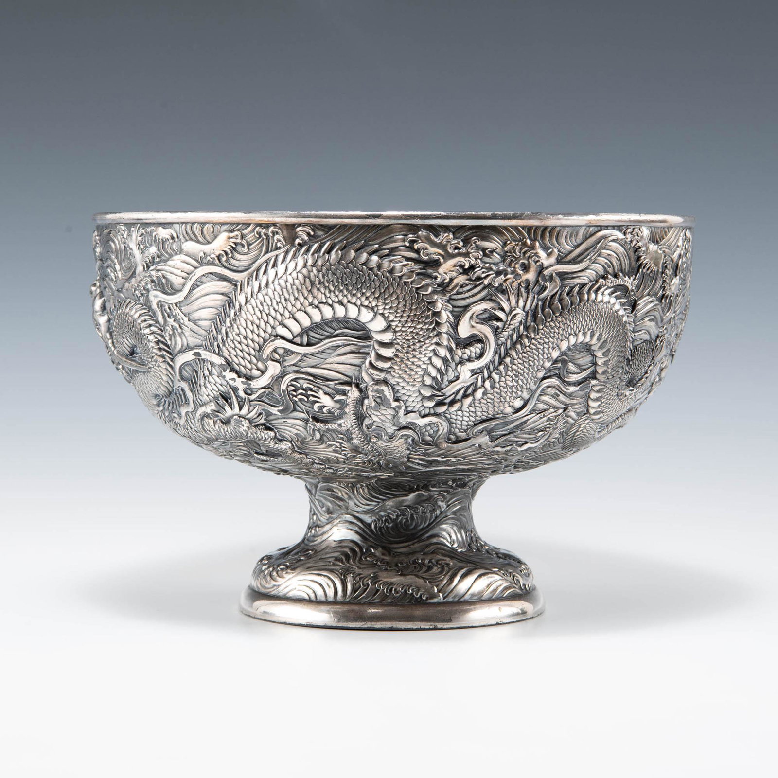 A Japanese silver-plated-metal footed bowl with dragons, Meiji period: A Japanese silver-plated-metal footed bowl with dragons Meiji period H: 7 1/4, Dia: 11 in. H: 18.42, Dia: 27.94 cm. Provenance: Private collection, Washington D.C.