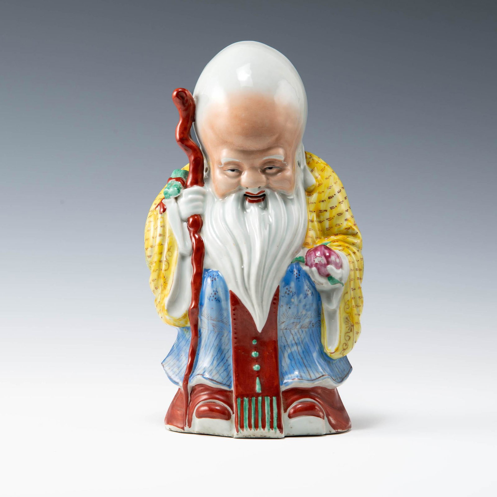 A Chinese famille rose porcelain statue of Shou, Republic period: A Chinese famille rose porcelain statue of Shou Republic period Clutching a staff in one hand, a peach in the other; with ten-character mark to underside. H: 12 3/4, W: 7 1/4, D: 4 1/2 in. H: 32.38, W