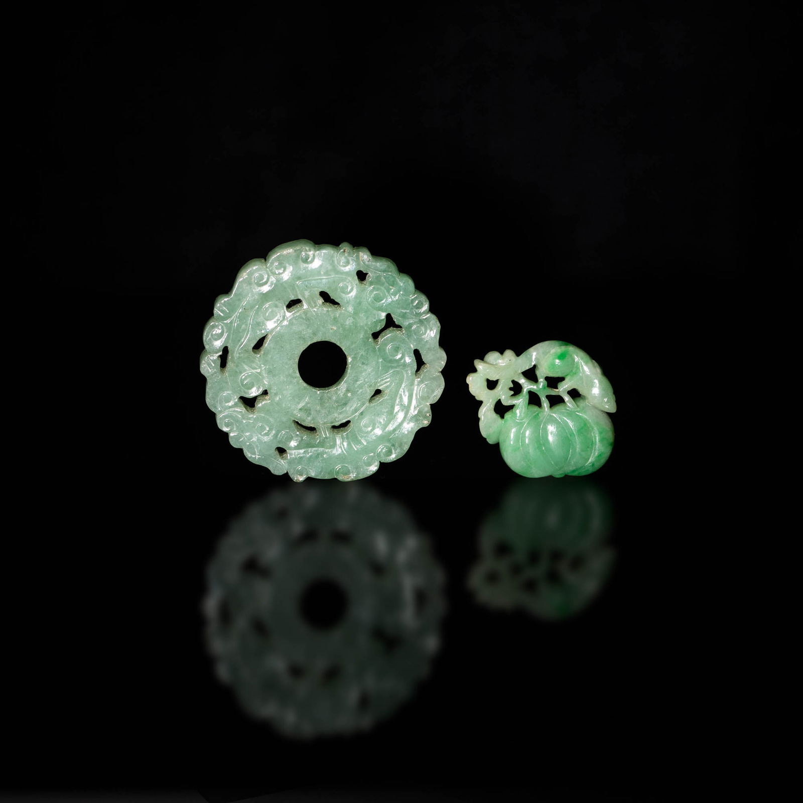 A Chinese carved jadeite toggle and jade bi, 19th century: A Chinese carved jadeite toggle and jade bi 19th century The toggle carved in the form of a pumpkin with a small animal perched on its stem. The bi carved as two stylized dragons forming a circle. (2)