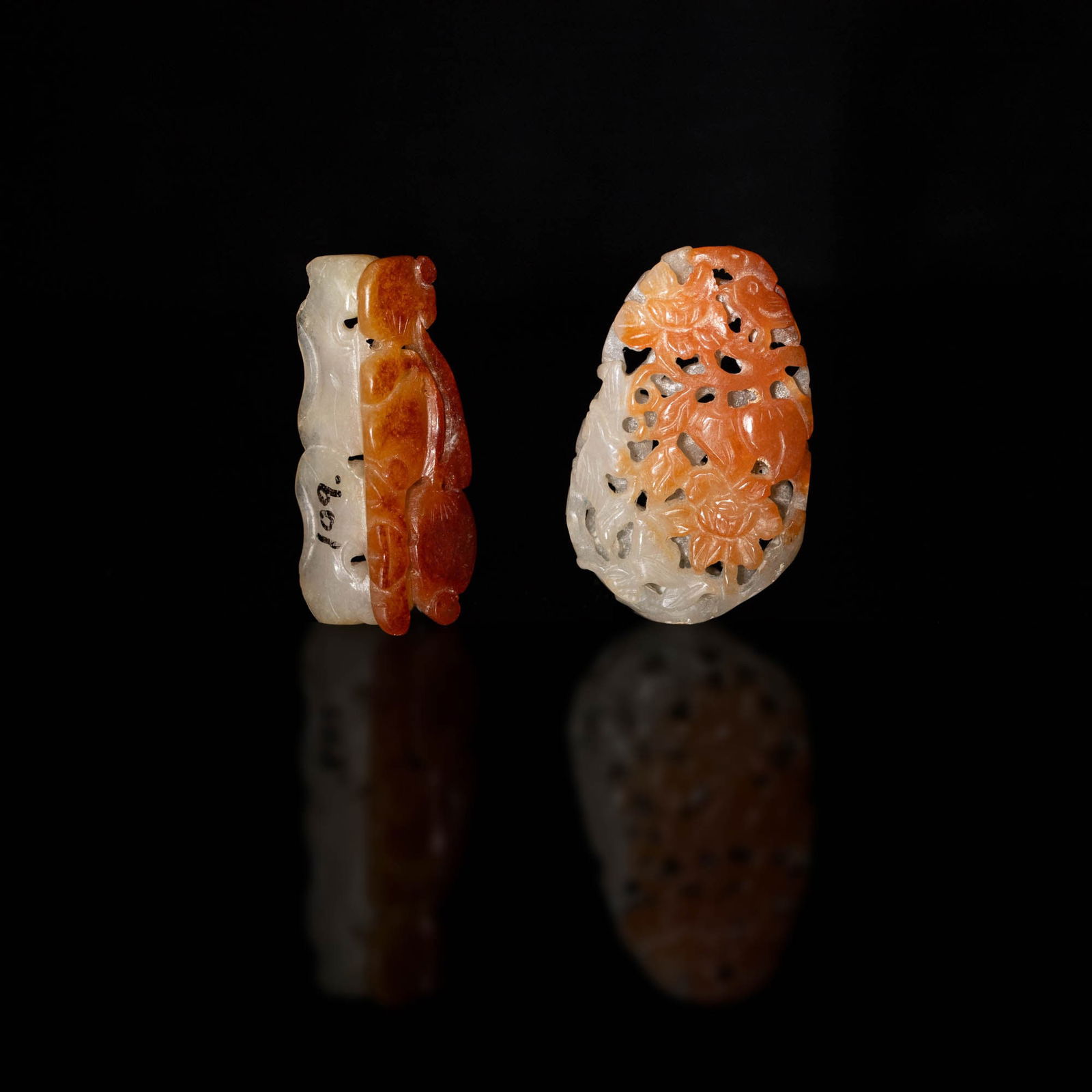 Two Chinese jadeite carvings, 19th century: Two Chinese jadeite carvings 19th century Comprising a hollow openwork-carved jadeite featuring birds among flowers and peach branches; and a carving with russet inclusions and previous collector mark