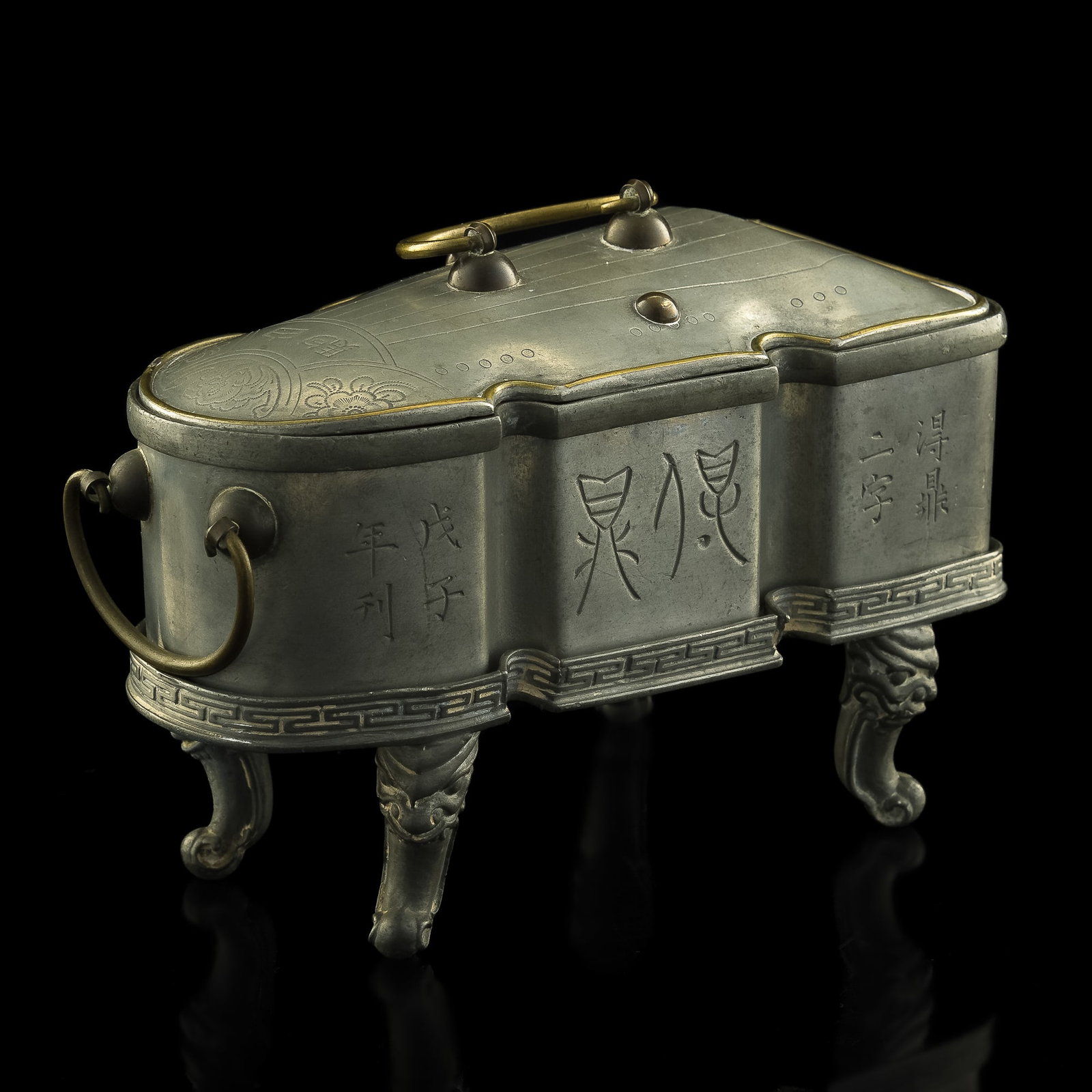 A Chinese tin-lidded box, late 19th century: A Chinese tin-lidded box late 19th century A lidded box featuring floral and circular motifs to lid with two character and two layers of box with outermost layer engraved with an inscription; all sitt