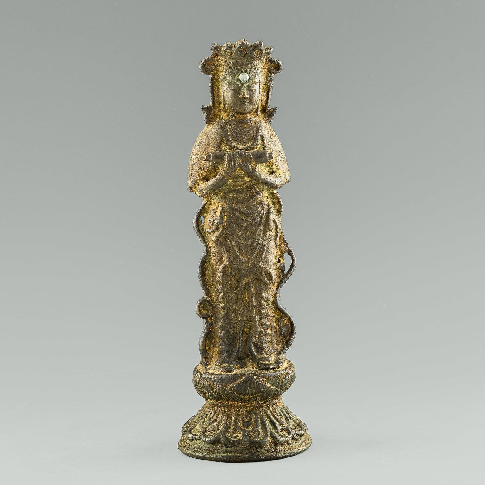 A Chinese bronze figure of Buddha, Ming dynasty: A Chinese bronze figure of Buddha Ming dynasty The Buddha stands on double-lotus pedestal, both hands grasping a scroll before his chest. With glass or stone inlaid cabochon to the Buddha's forehead. 