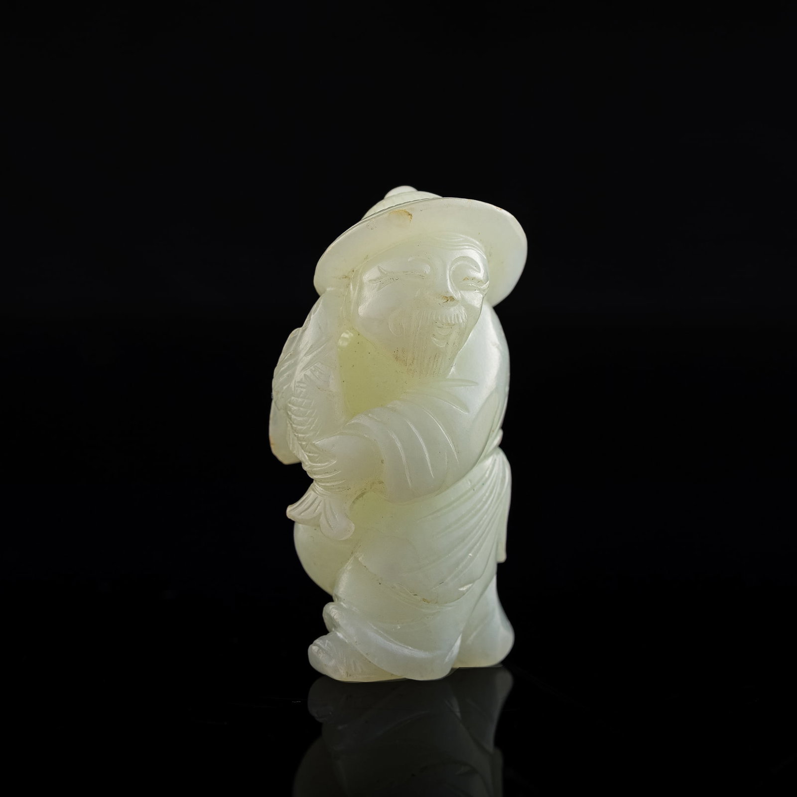 A Chinese carved white jade 'fisherman' figure, 18th/19th century: A Chinese carved white jade 'fisherman' figure 18th/19th century H: 2, W: 1, D: 3/4 in. H: 5.08, W: 2.54, D: 1.91 cm. Provenance: Mr. Ng, New Orleans, Louisiana. Acquired by his late parents in Hong K