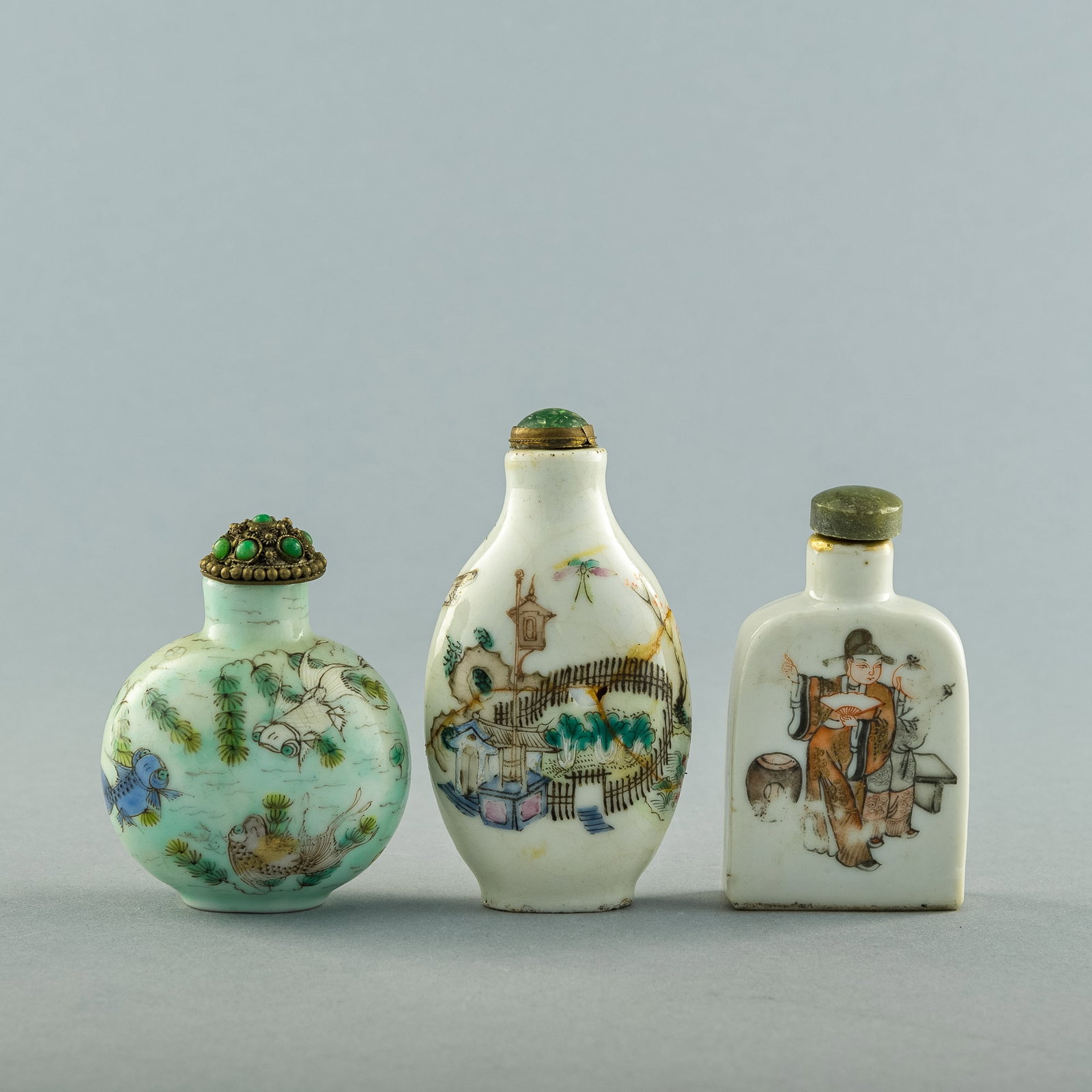Three Chinese famille rose snuff bottles, 19th century: Three Chinese famille rose snuff bottles 19th century Comprising an ovoid bottle with landscape; a blue-ground bottle with fish and four-character mark to underside; and a bell-form bottle with figure