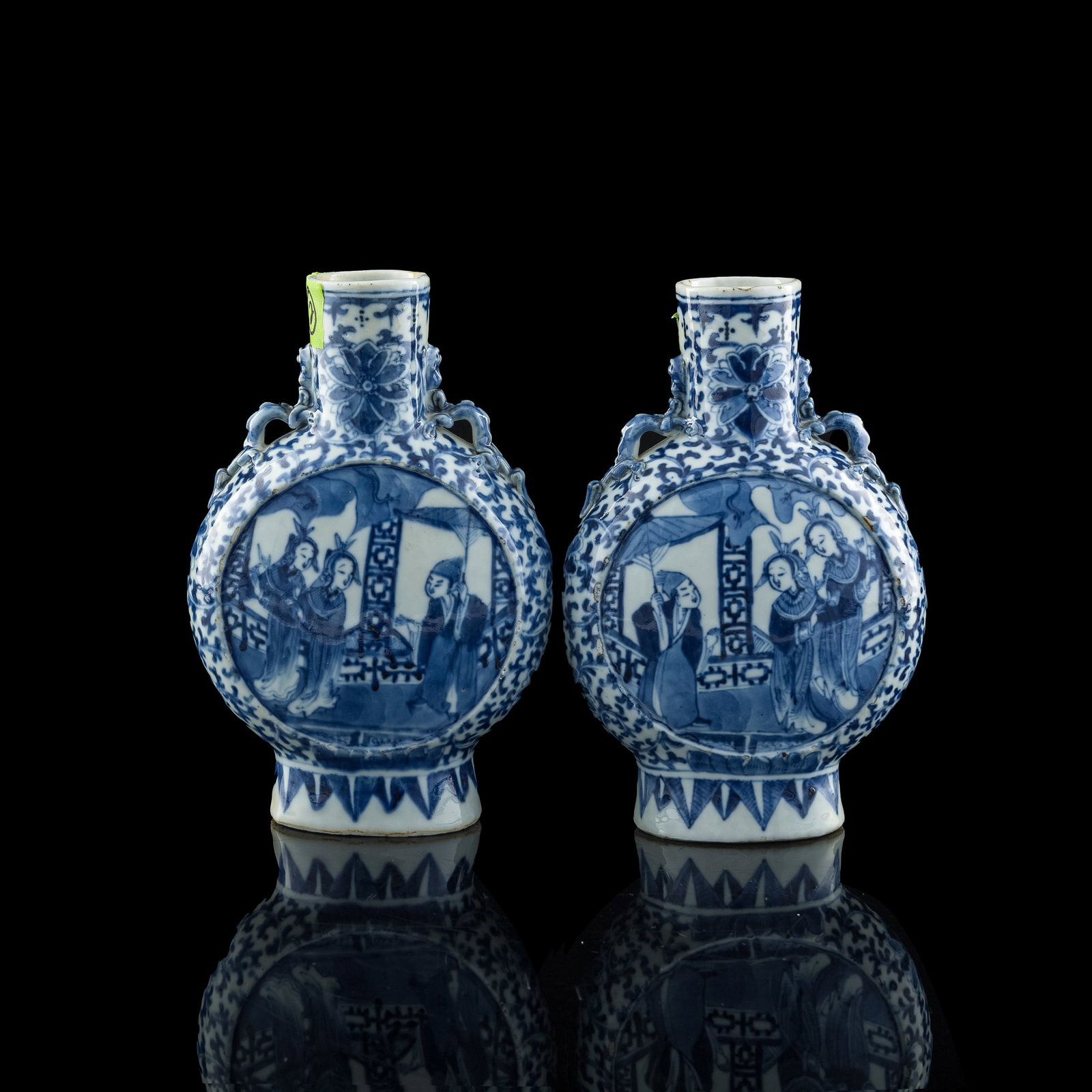 A pair of Chinese blue and white 'figural' moonflasks, late 19th century: A pair of Chinese blue and white 'figural' moonflasks late 19th century Both with central roundels depicting figures in pavilions. (2). H: 8 1/8, W: 5 1/4, D: 2 3/4 in. (H: 20.64, W: 13.34, D: 6.99 cm
