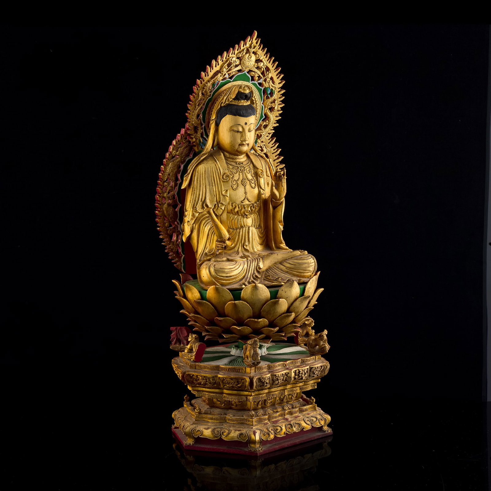 A Chinese gilt-wood statue of Guanyin, Qing dynasty: A Chinese gilt-wood statue of Guanyin Qing dynasty Statue comprising hexagonal plinth, lotus base, seated Guanyin, and carved hulu-shaped mandorla. H: 24 1/2, W: 10 5/8, D: 8 3/8 in. (H: 62.23, W: 26.