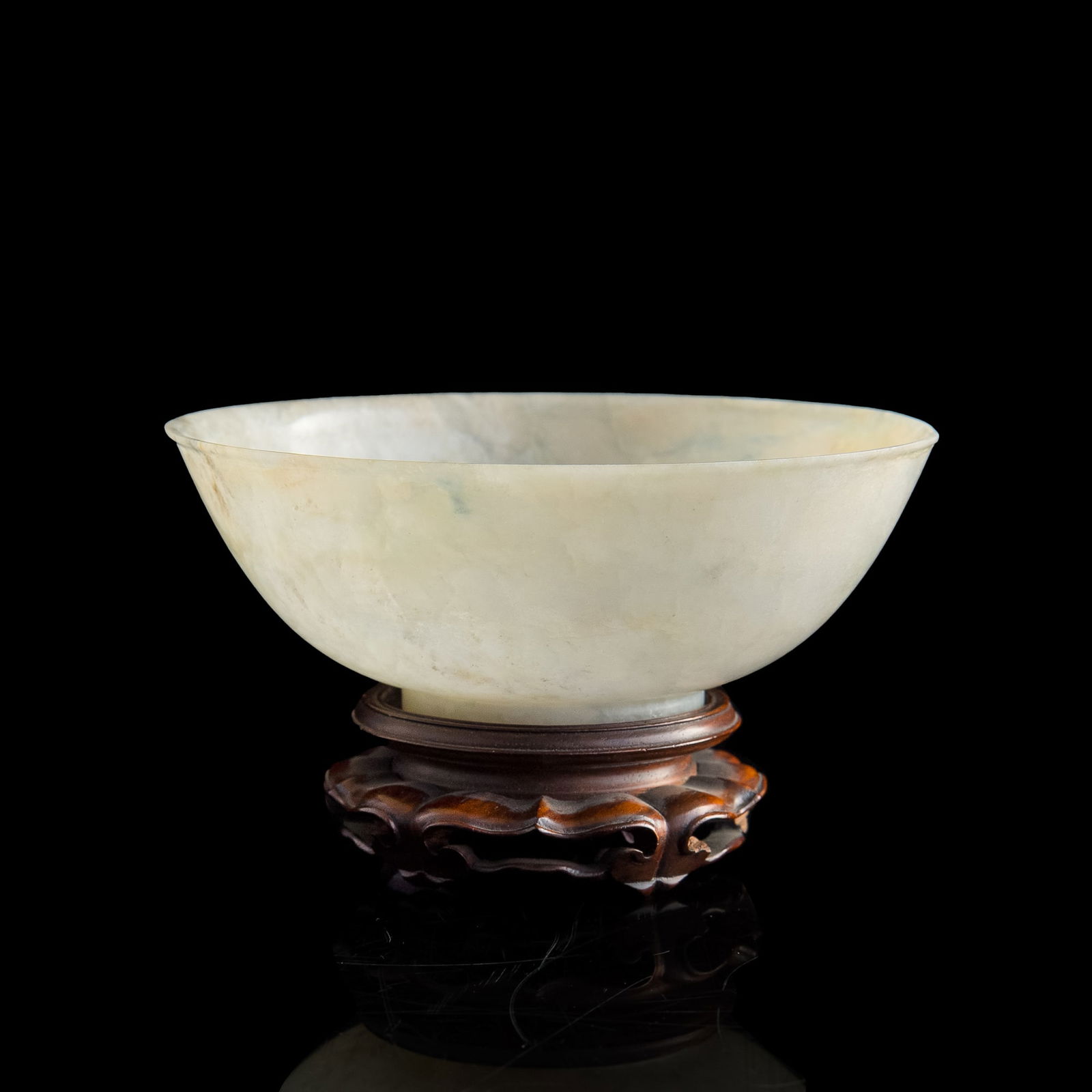 A Chinese carved jadeite bowl, 18th/19th century: A Chinese carved jadeite bowl 18th/19th century Sold with one associated wooden stand. H: 2, Dia: 5 1/2 in. (H: 5.08, Dia: 13.97 cm. (jade)) Provenance: Private collection, North Carolina. Gift of Fra