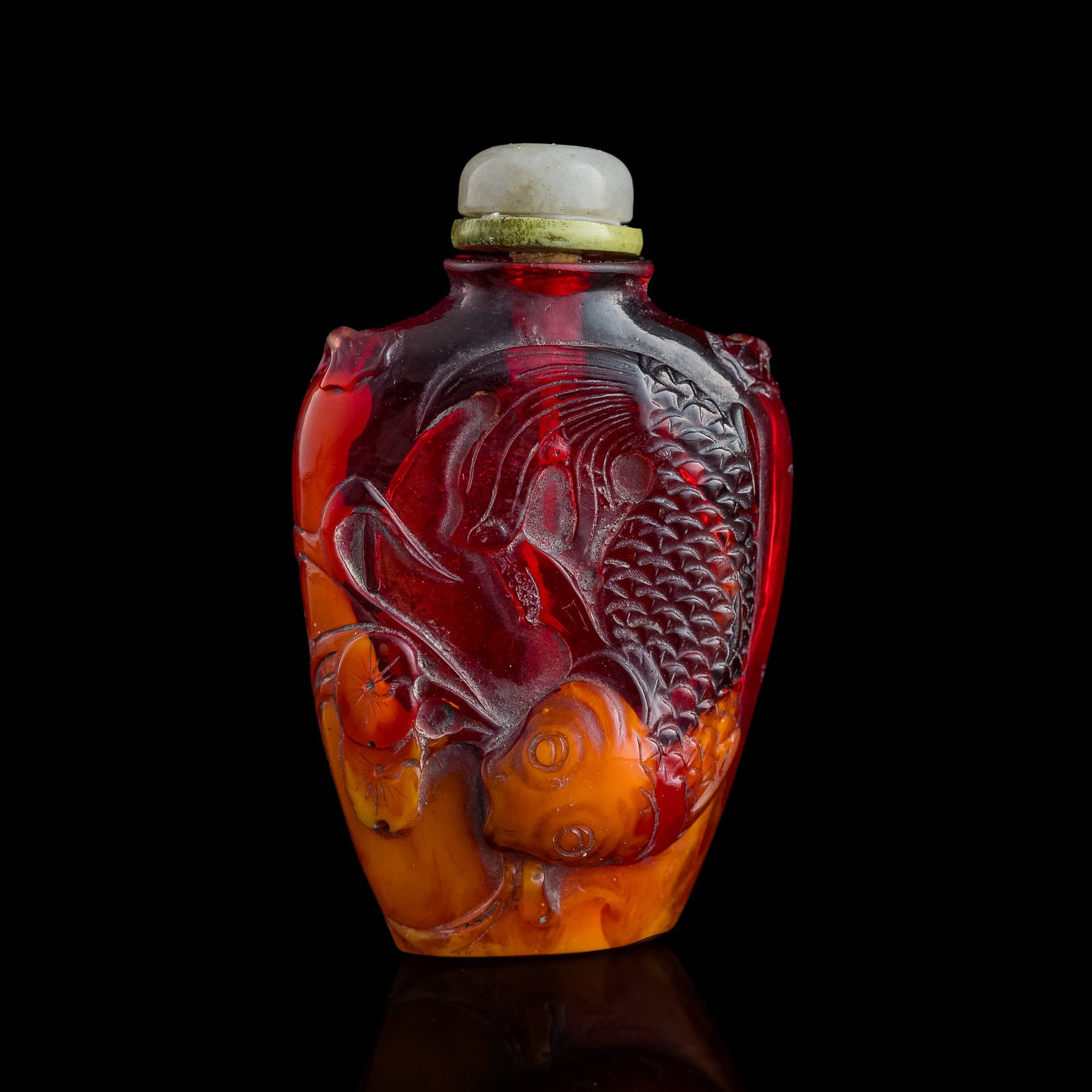 A Chinese carved celluloid 'fish' snuff bottle, Republic period: A Chinese carved celluloid 'fish' snuff bottle Republic period The upper section of the bottle is carved of a clear, red celluloid, while the inclusion filling the lower section is of a lightly banded