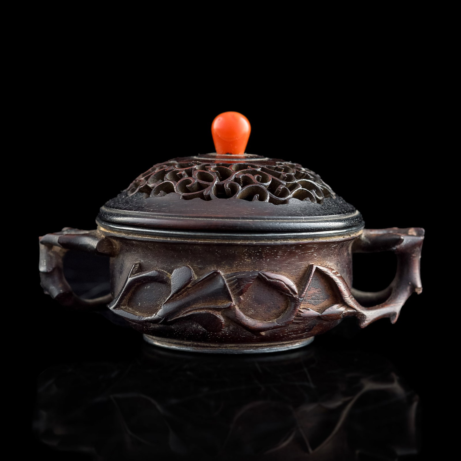 A Chinese carved zitan 'flower' censer, 18th century: A Chinese carved zitan 'flower' censer 18th century The stout censer is decorated to the bulging center with flowers in high relief, whose branches reach beyond the bounds of the register to create bo