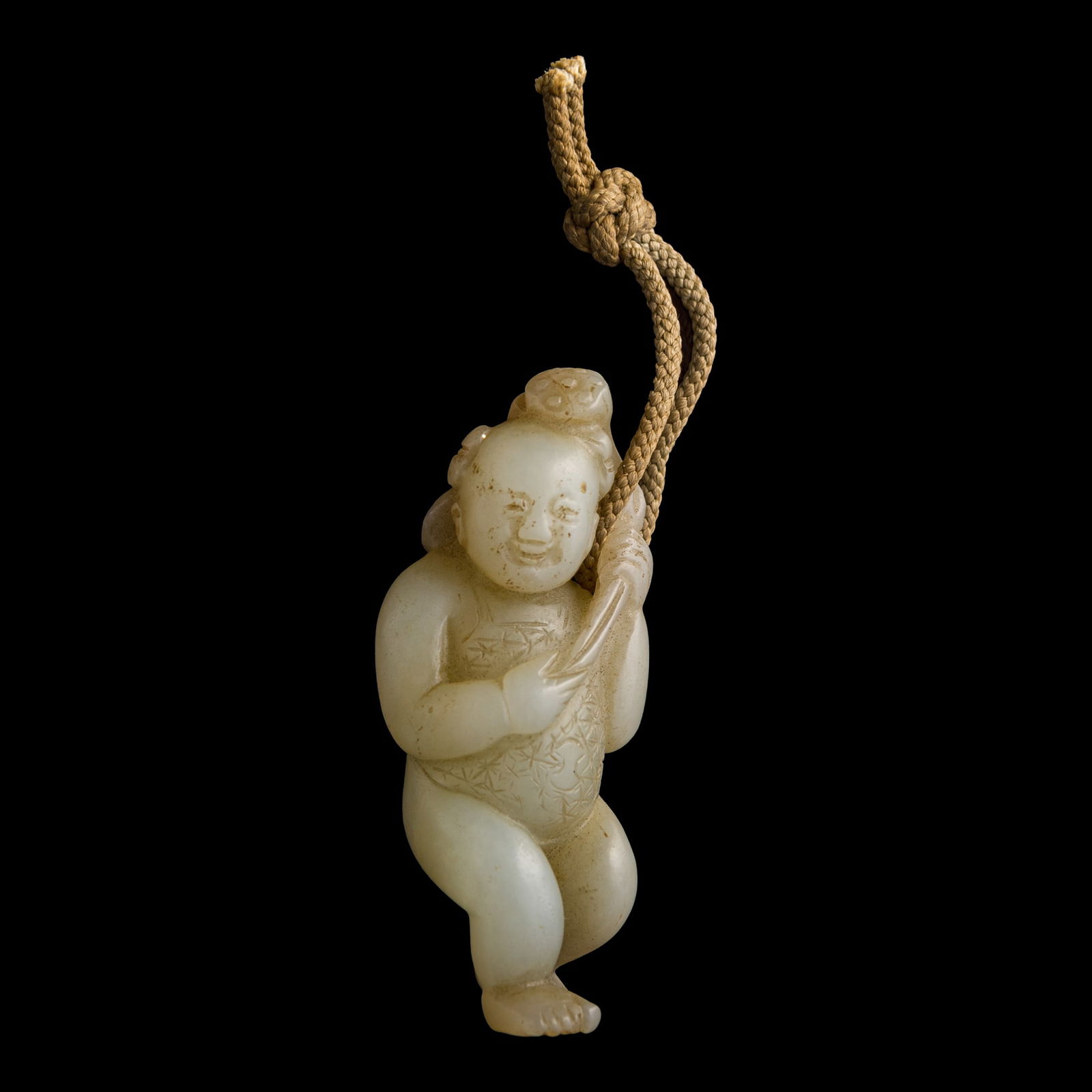 A Chinese carved white jade boy holding lotus, 18th century
