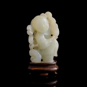 A Chinese carved white jade boy holding lotus, early 19th century