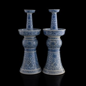 A pair of Chinese blue and white 'scrolling lotus' candle holders, 19th century