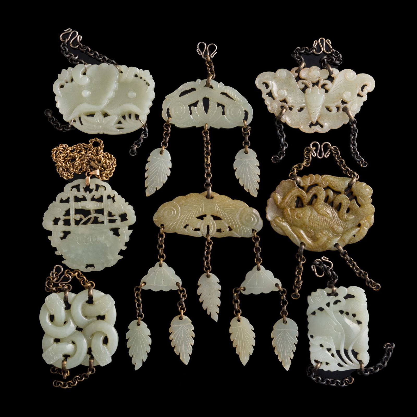Seven assorted Chinese jade accessories: Seven assorted Chinese jade accessories The group includes: a plaque with flowers and lingzhi in a vase on a chain marked 14K with initials KTYL; a jade pendant with nine pieces carved with leaves; a