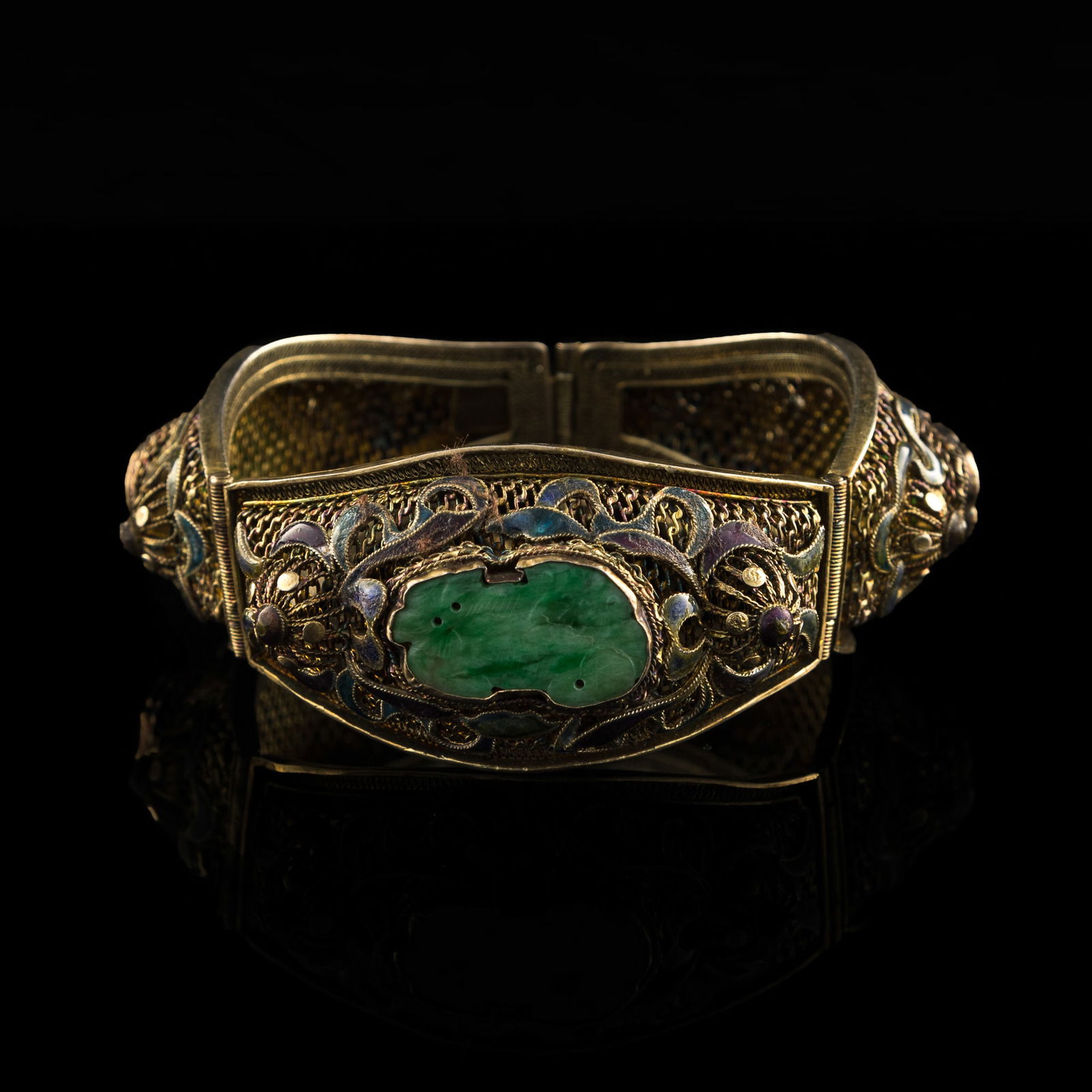 A Chinese silver-enameled bangle inset with three jadeite guardian lion plaques: A Chinese silver-enameled bangle inset with three jadeite guardian lion plaques H: 1 1/4, W: 3 1/4 in. (H: 3.18, W: 8.26 cm.) Weight: 50.38 g (approximately) From Mrs. Hillebrand in Chicago, Illinois.